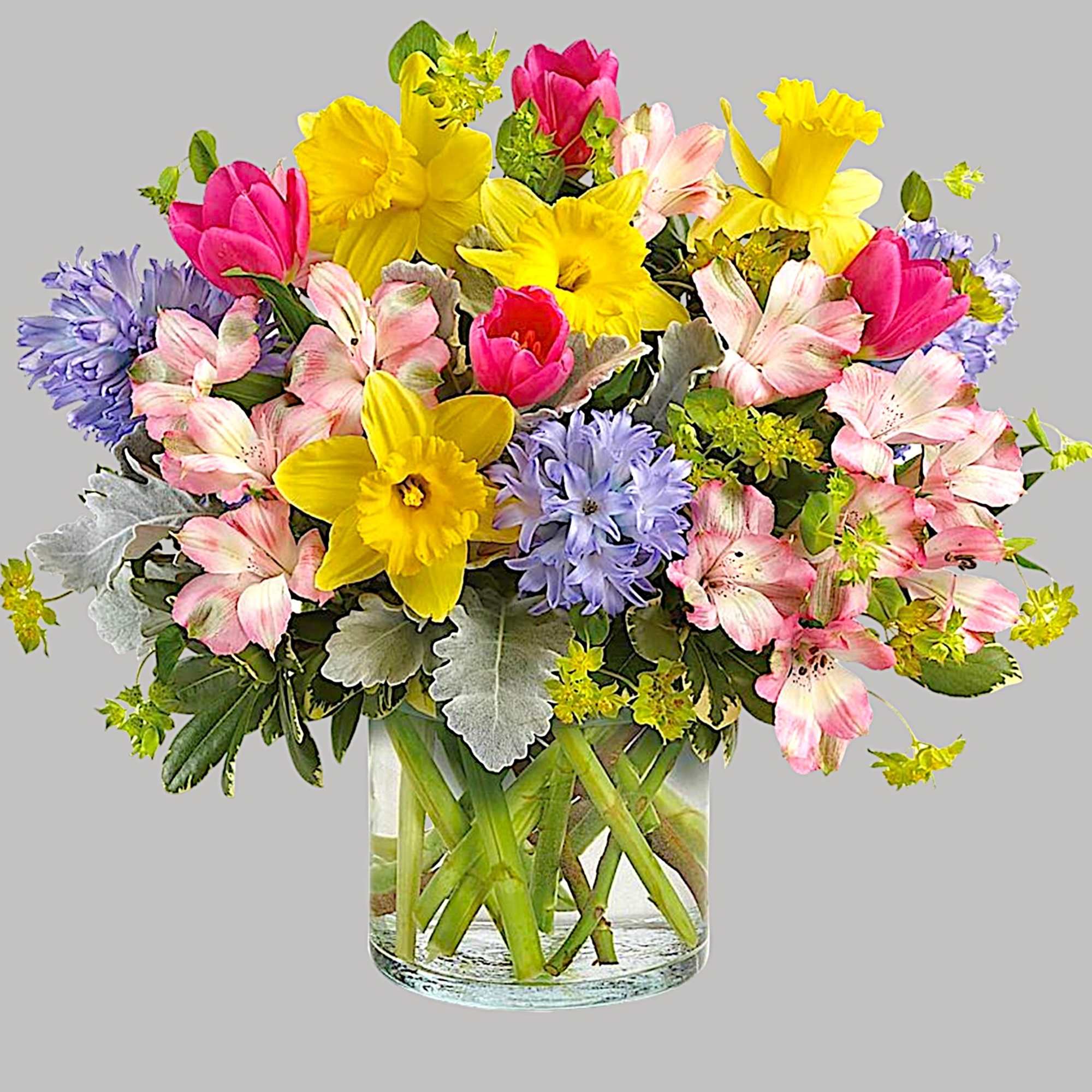 Colorful bouquet of daffodils, tulips, and alstroemeria in a glass vase