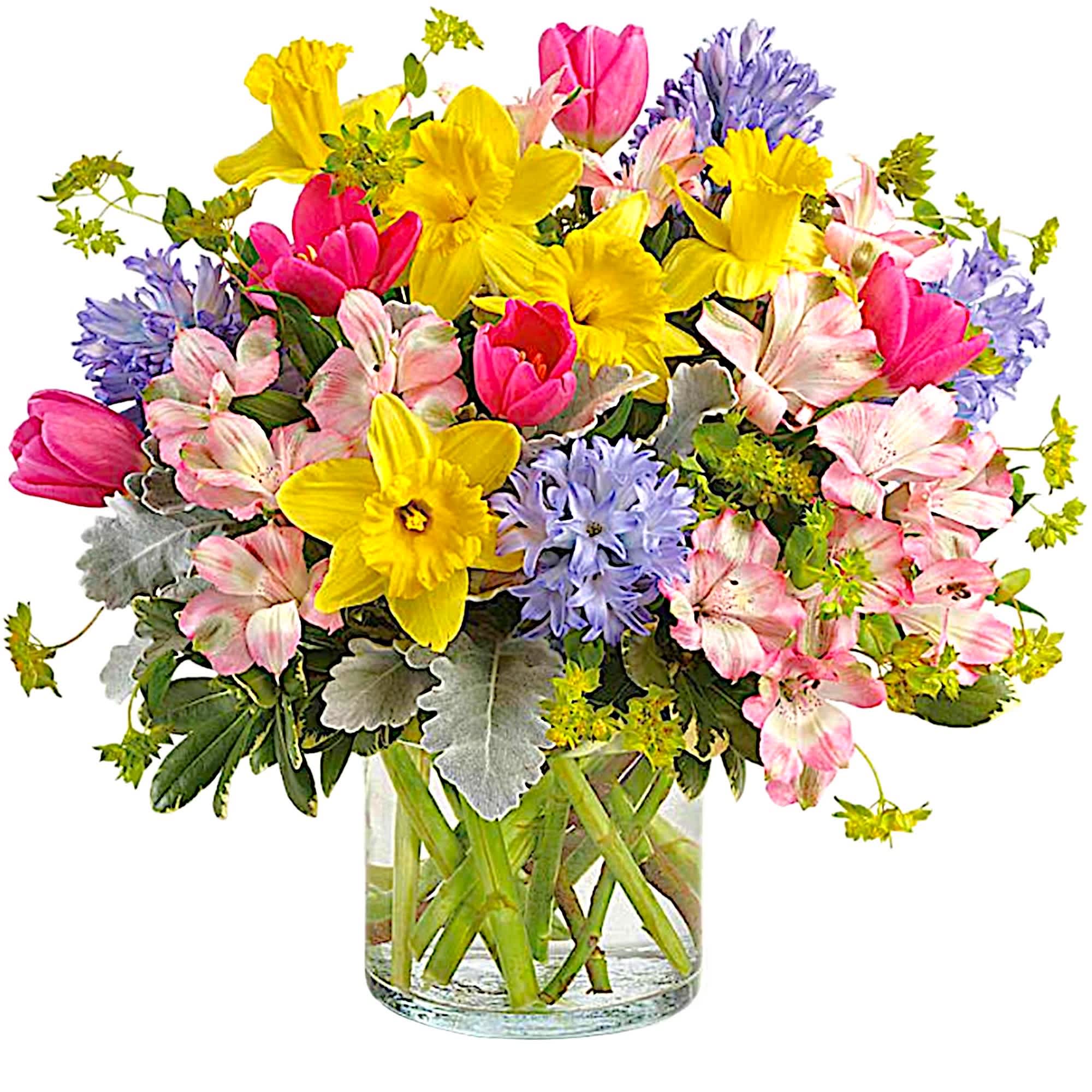 Colorful bouquet of daffodils, tulips, and alstroemeria in a glass vase