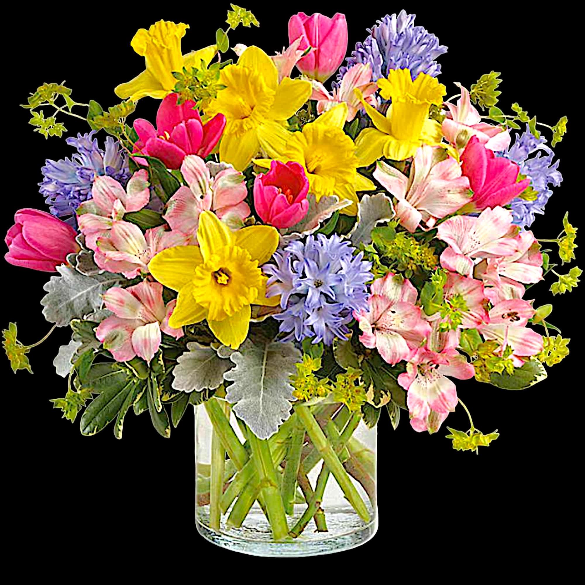 Mixed bouquet of yellow daffodils, pink tulips, and purple flowers in a glass vase
