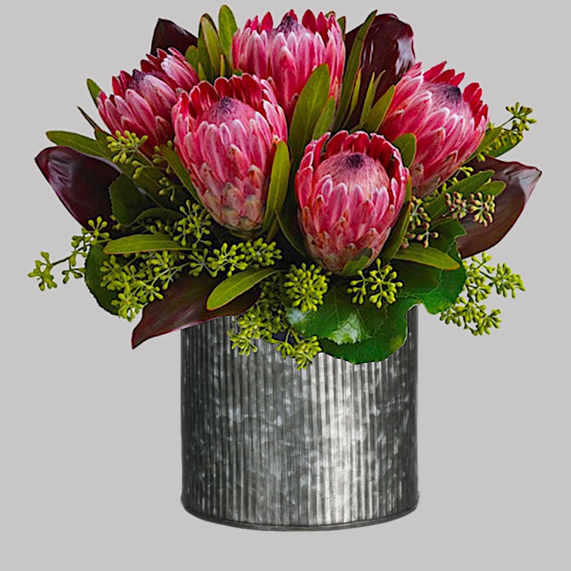 Pink protea arrangement in a ribbed metal vase