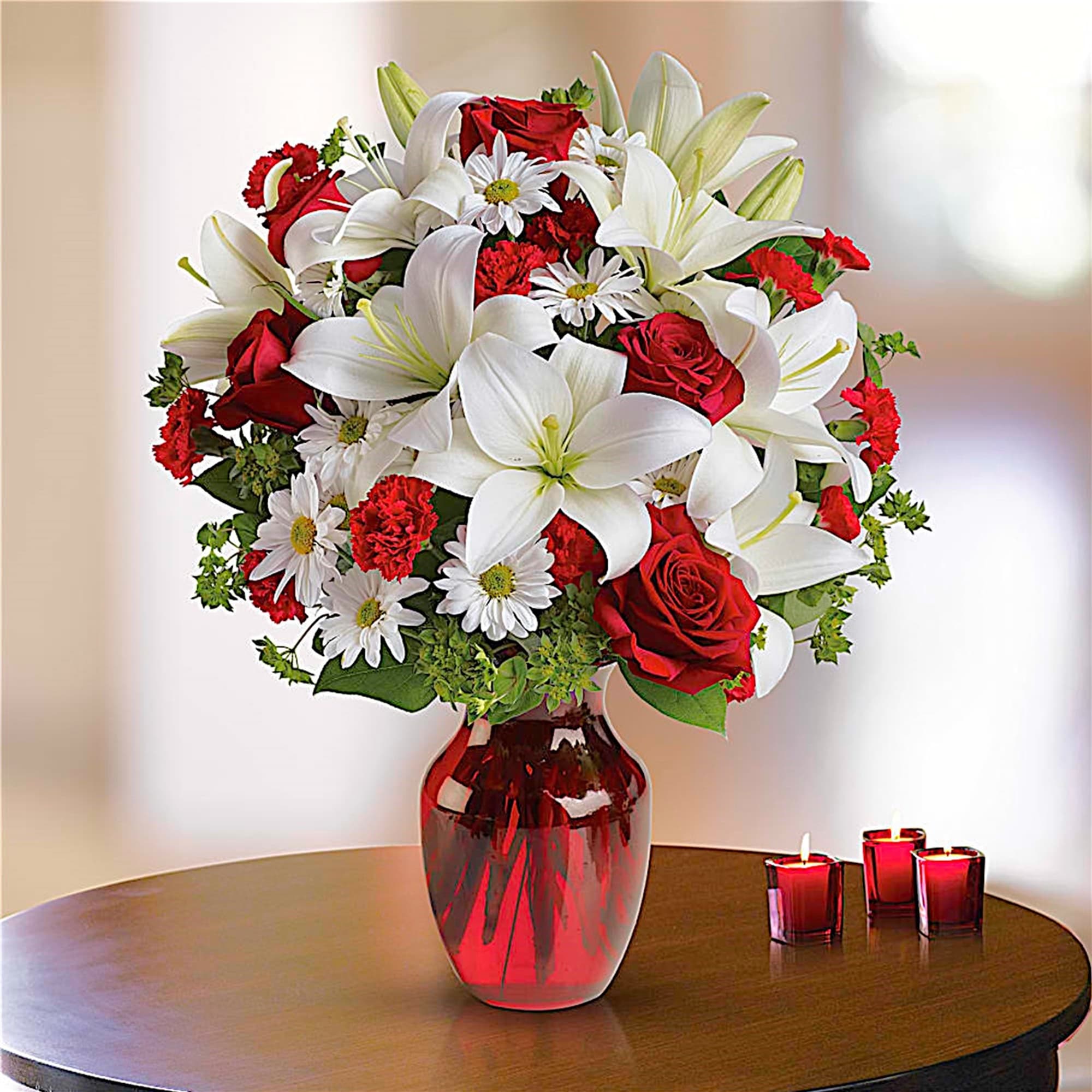 Bouquet of red roses and white lilies in a red glass vase