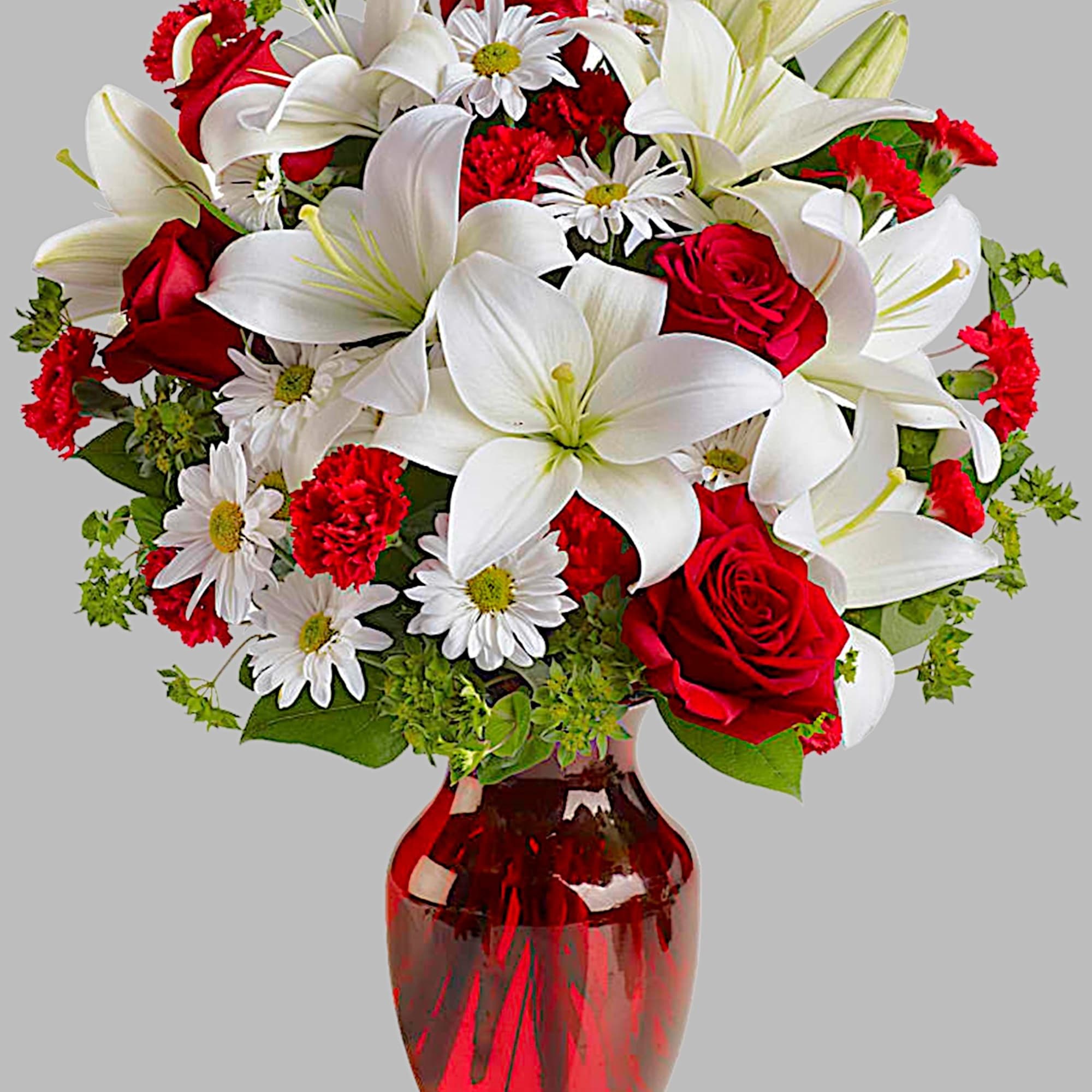 Red roses and white lilies arranged in a red glass vase