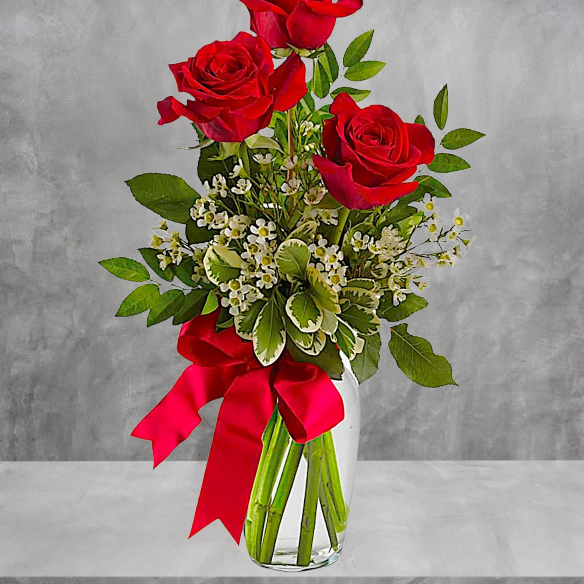 Red roses in a clear glass vase with a red ribbon, photo 3 of 5