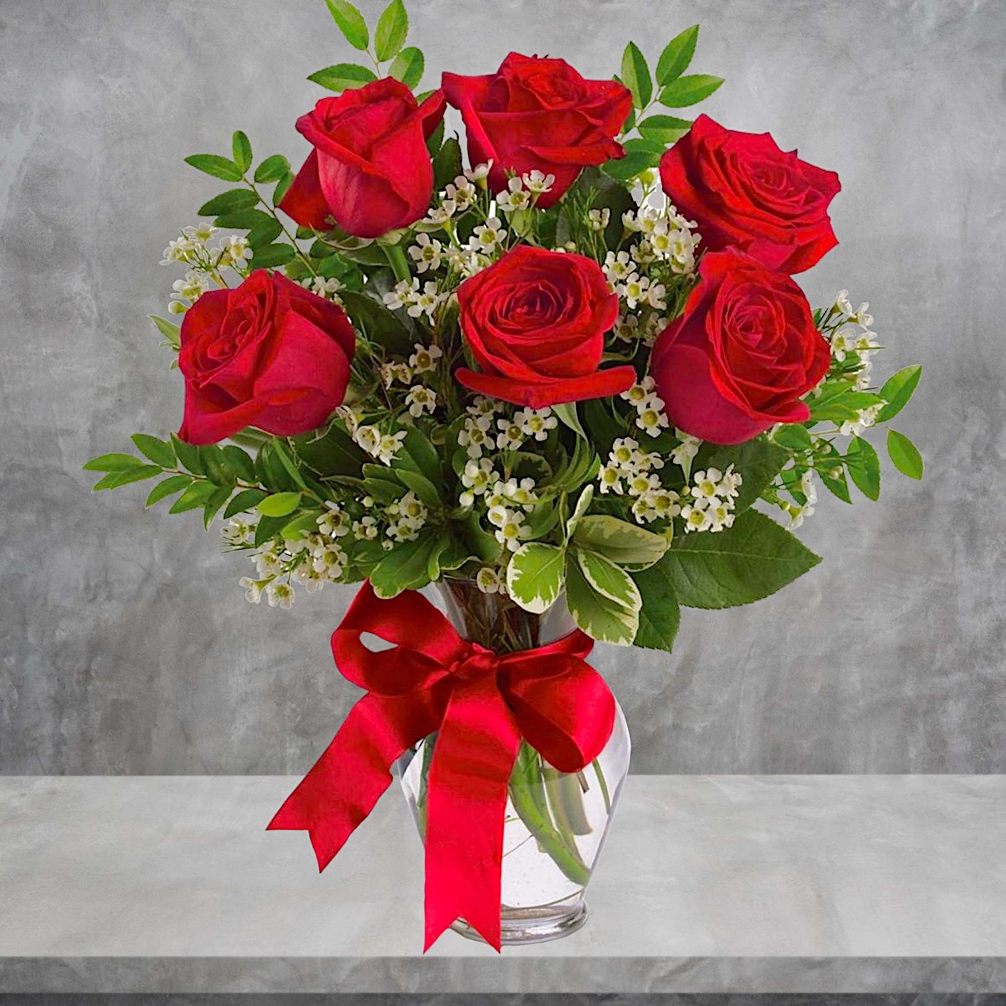 Red roses in a clear glass vase with a red ribbon, photo 3 of 5