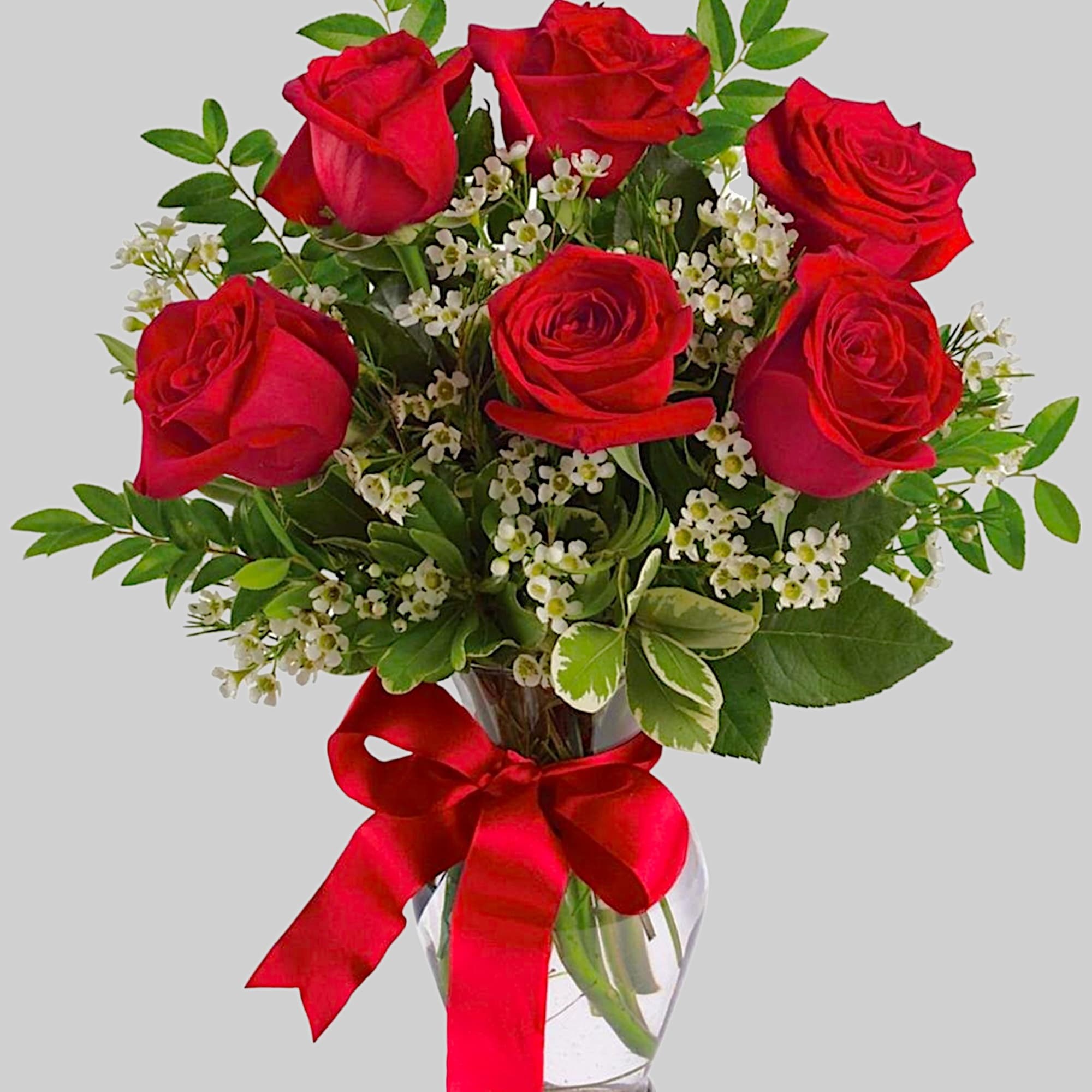 Red roses in a clear glass vase with a red ribbon, photo 5 of 5