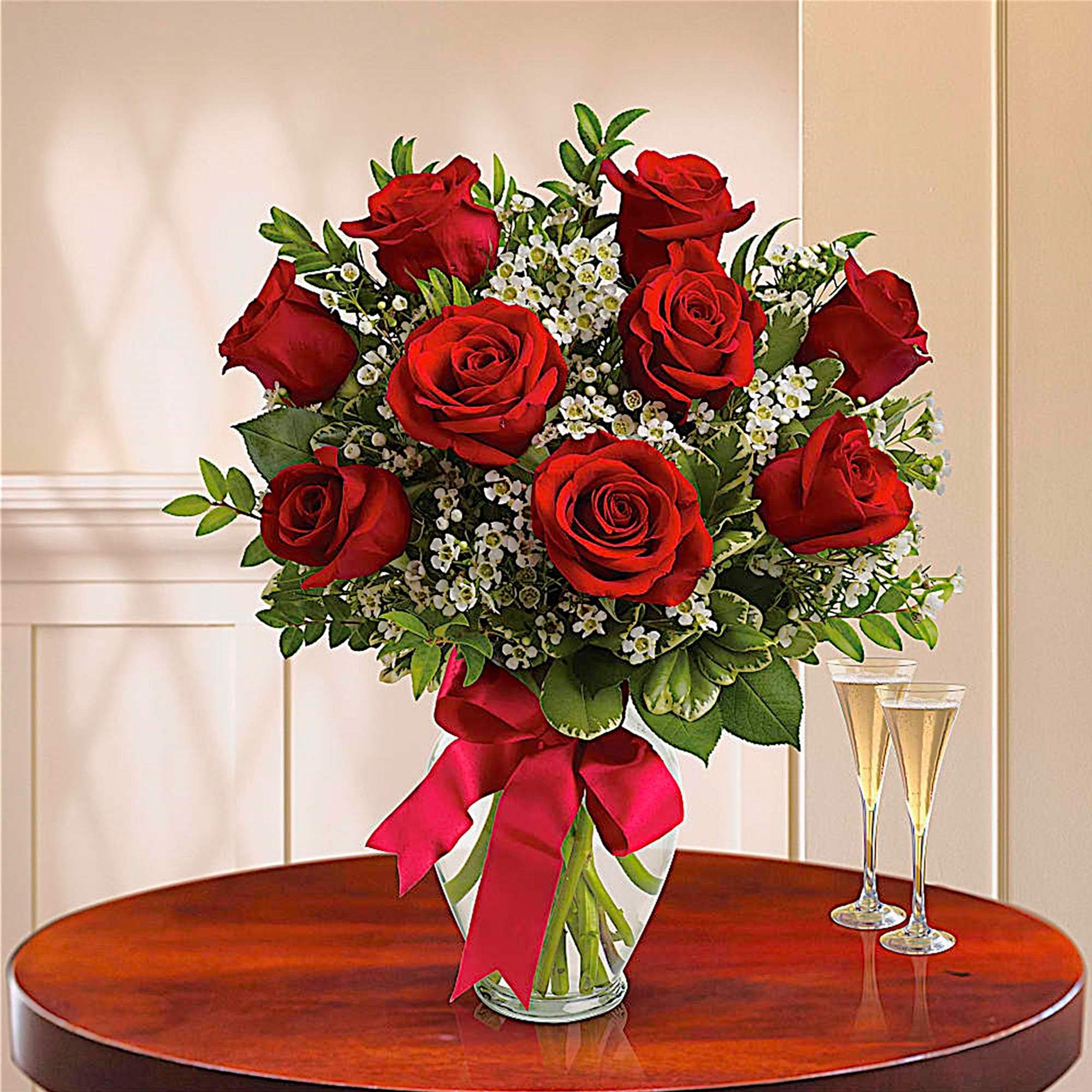 Bouquet of red roses in a glass vase with a red ribbon