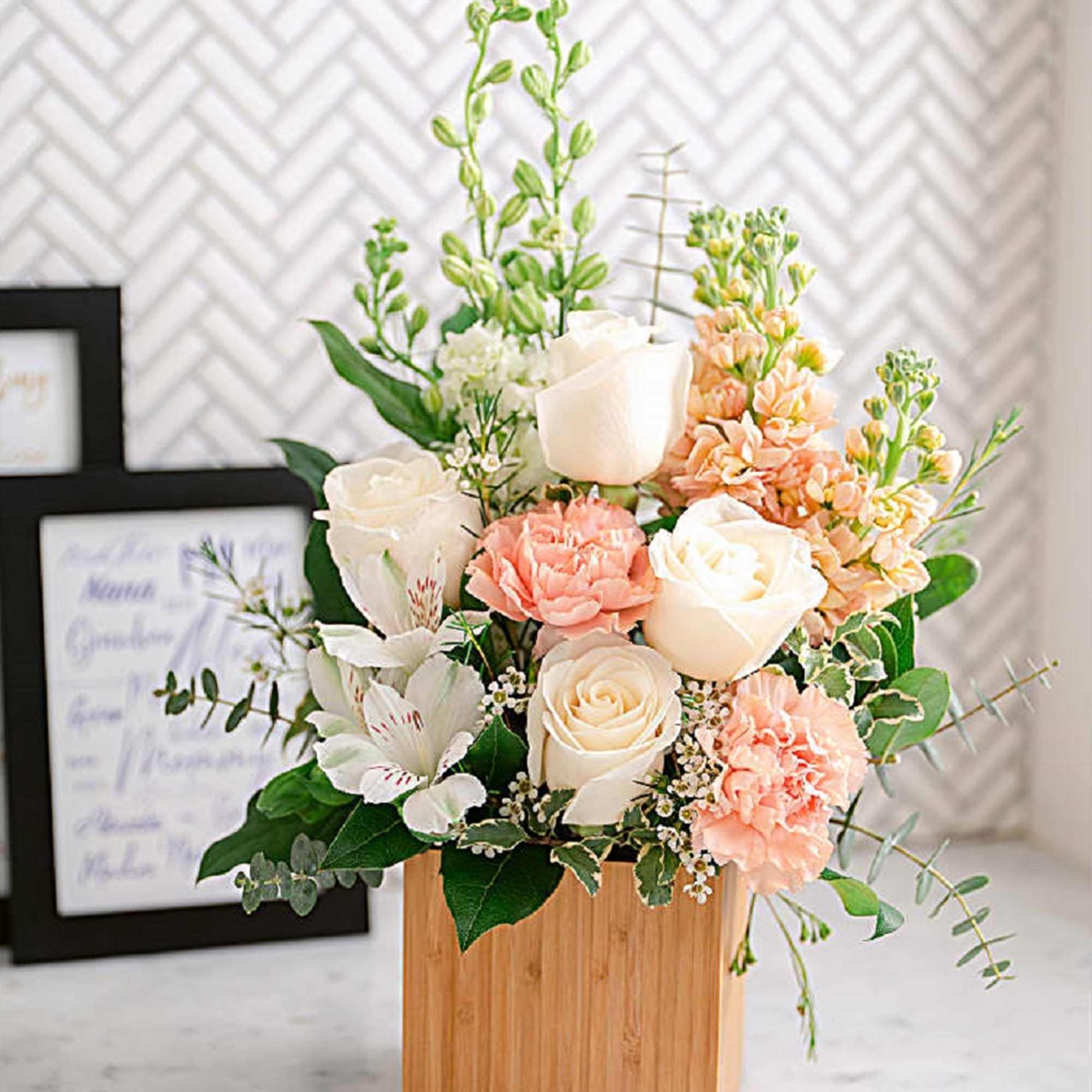 White and peach floral arrangement in a wooden box
