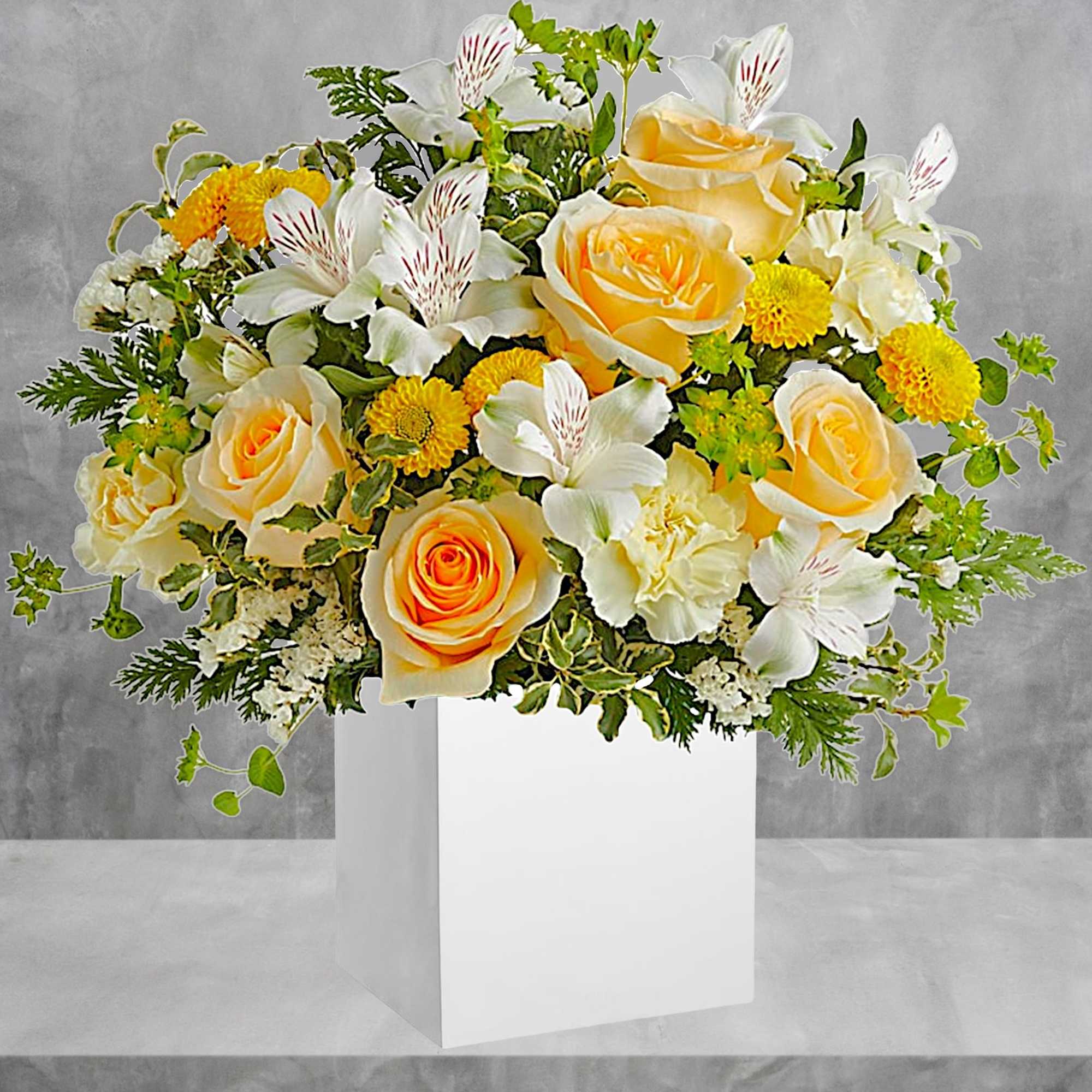 Yellow roses and white lilies in a white box vase
