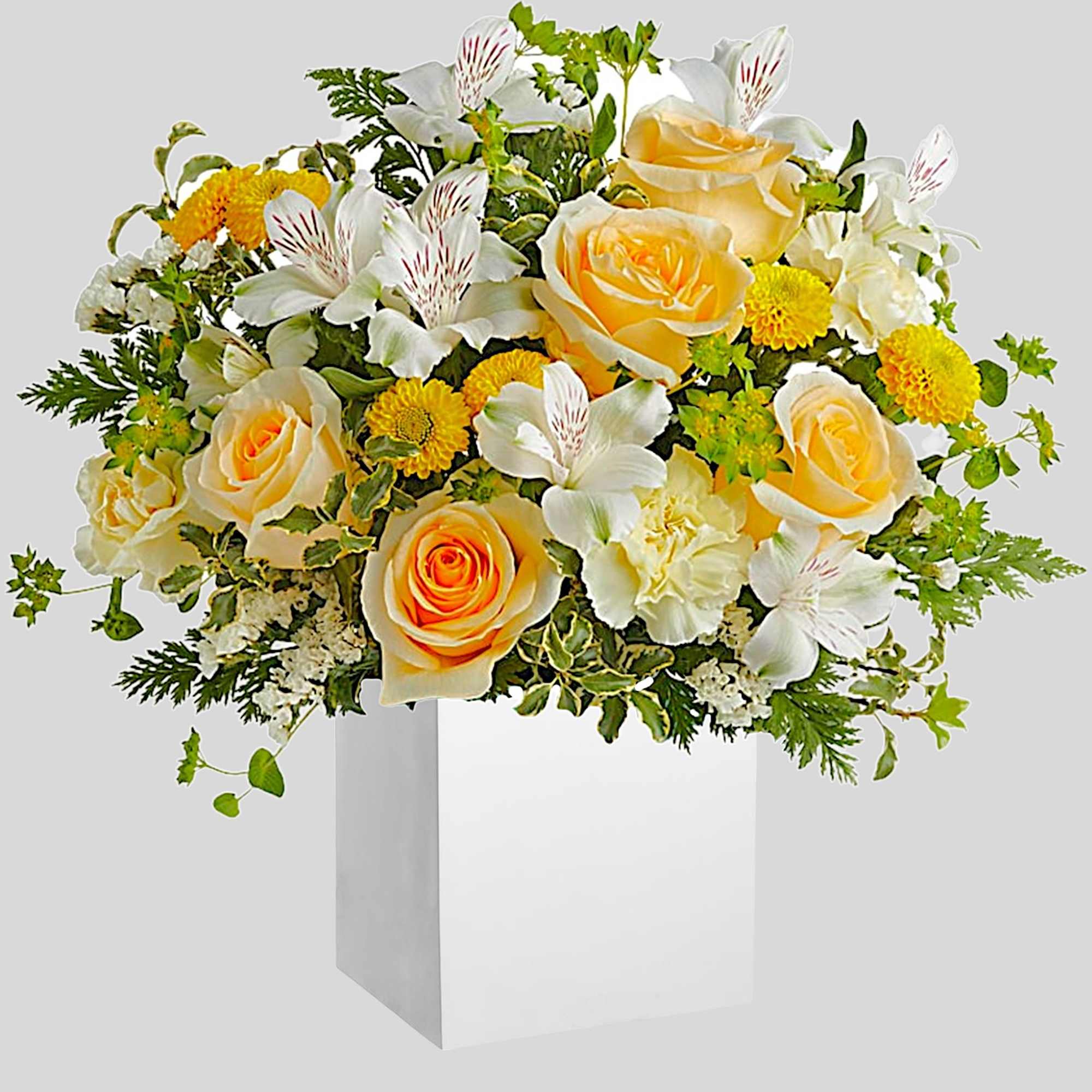 Yellow roses and white flowers arranged in a white gift bag