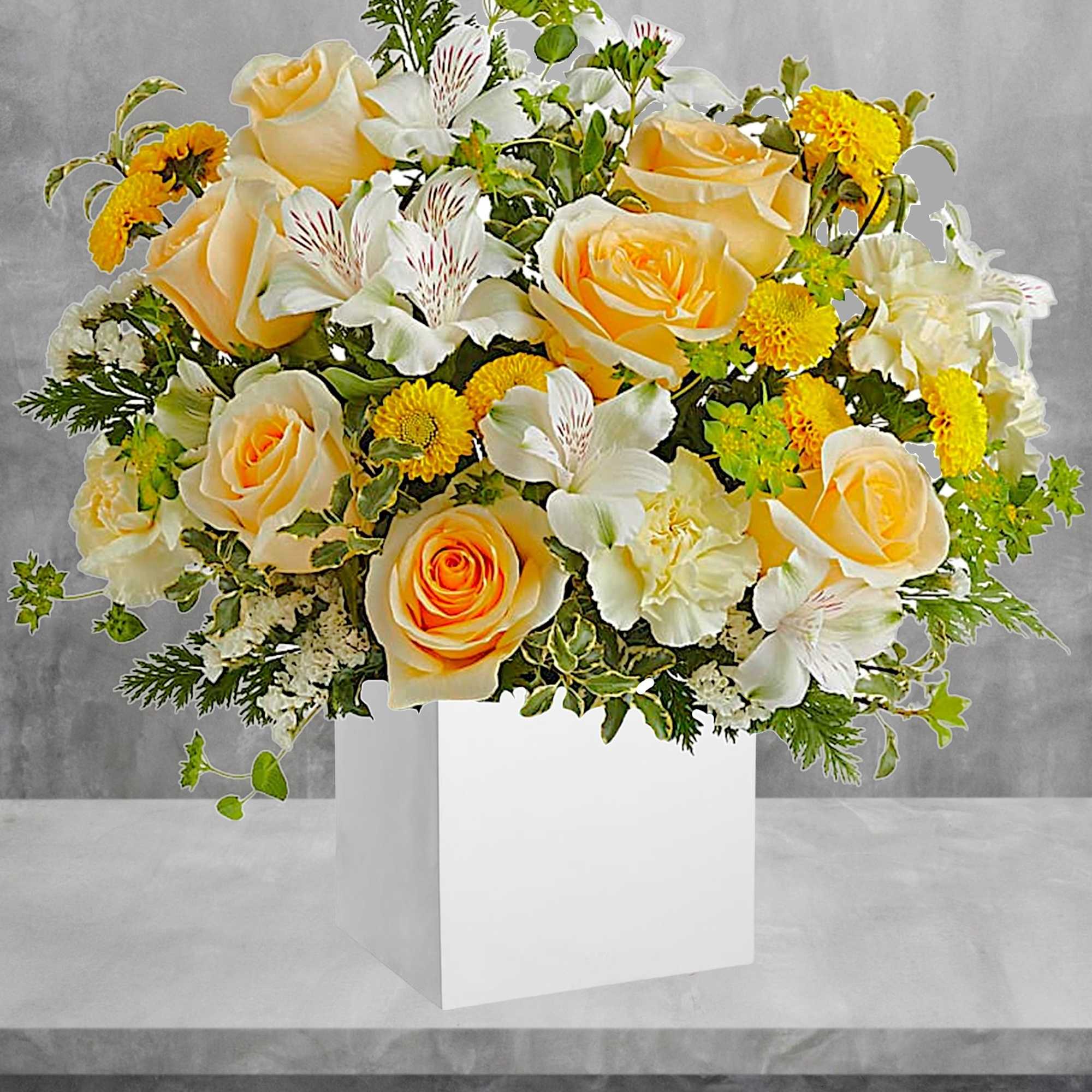 Yellow roses and white flowers arranged in a white box