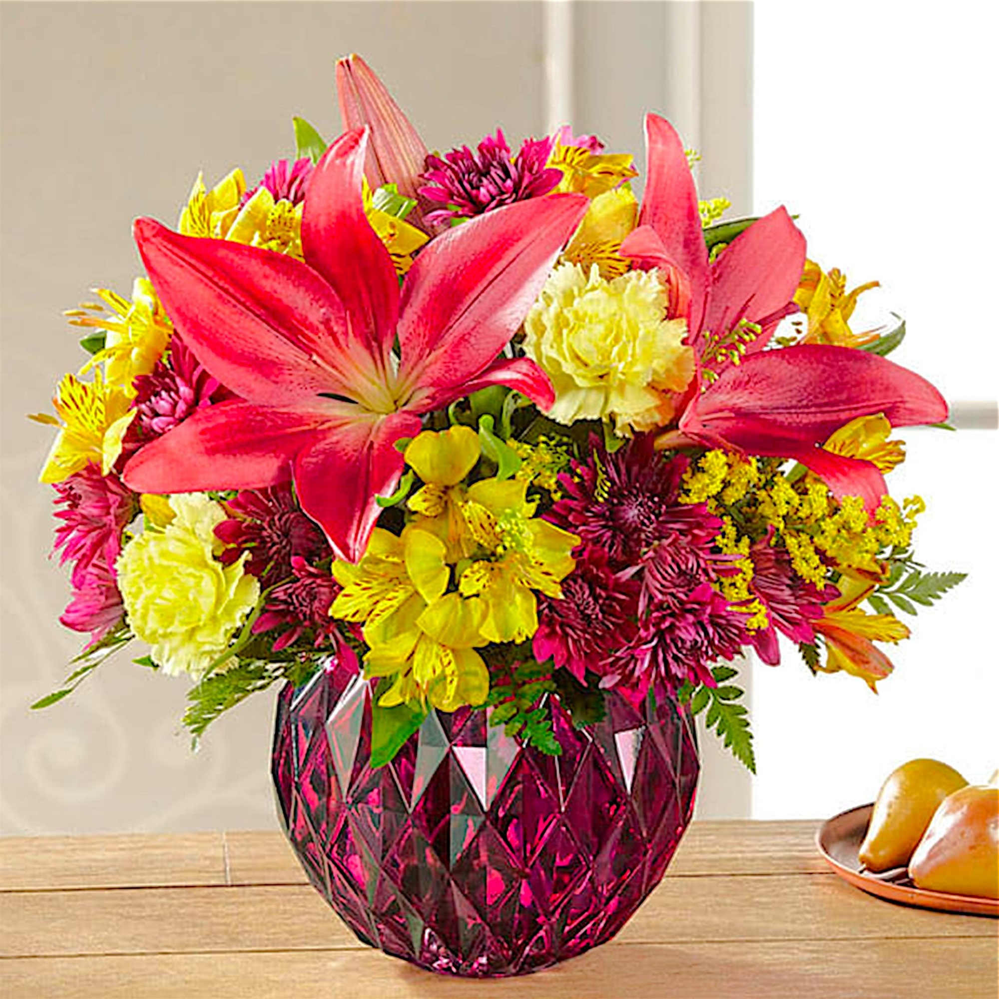 Bright mixed bouquet with pink lilies in a magenta vase