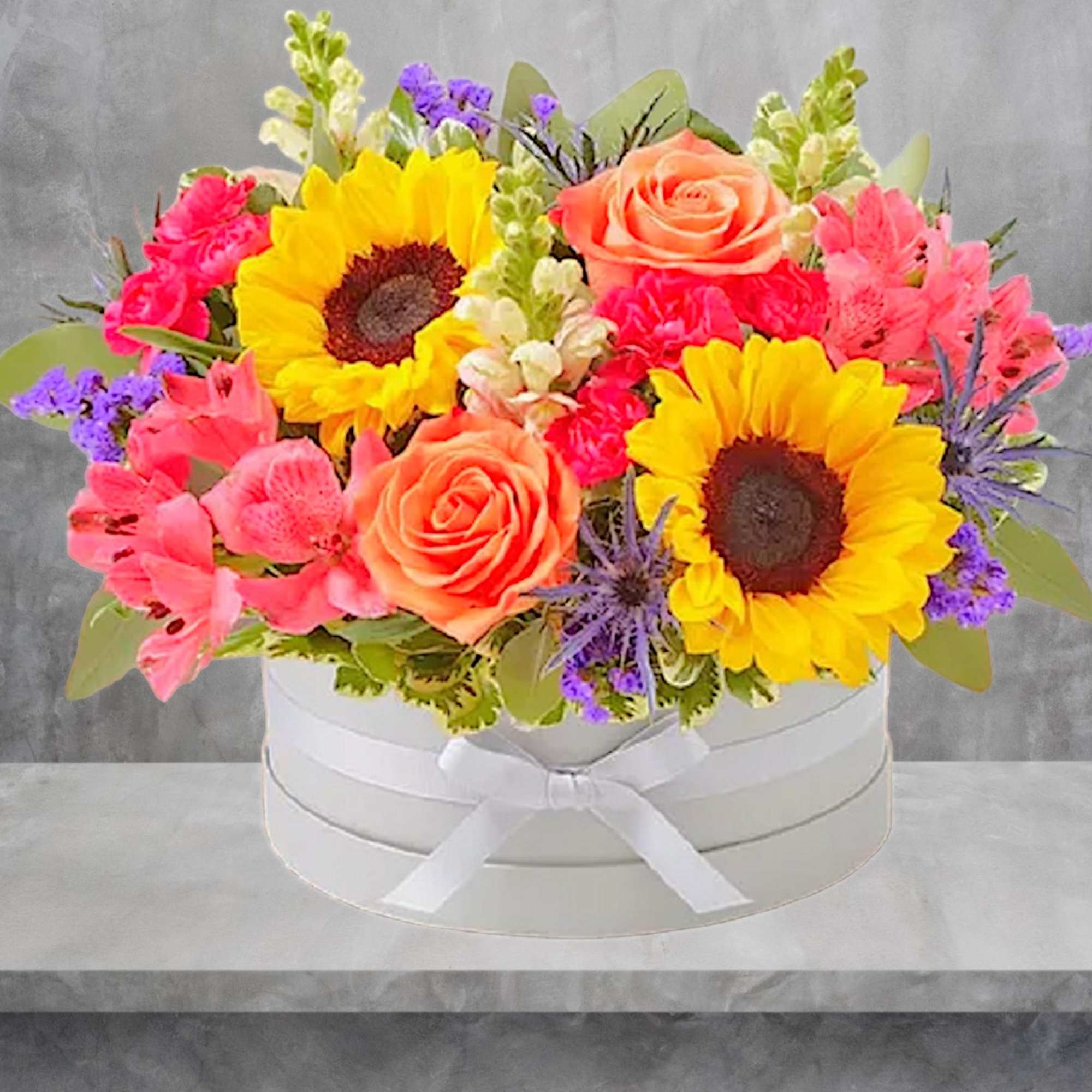 Bright mixed bouquet in a white round box with ribbon