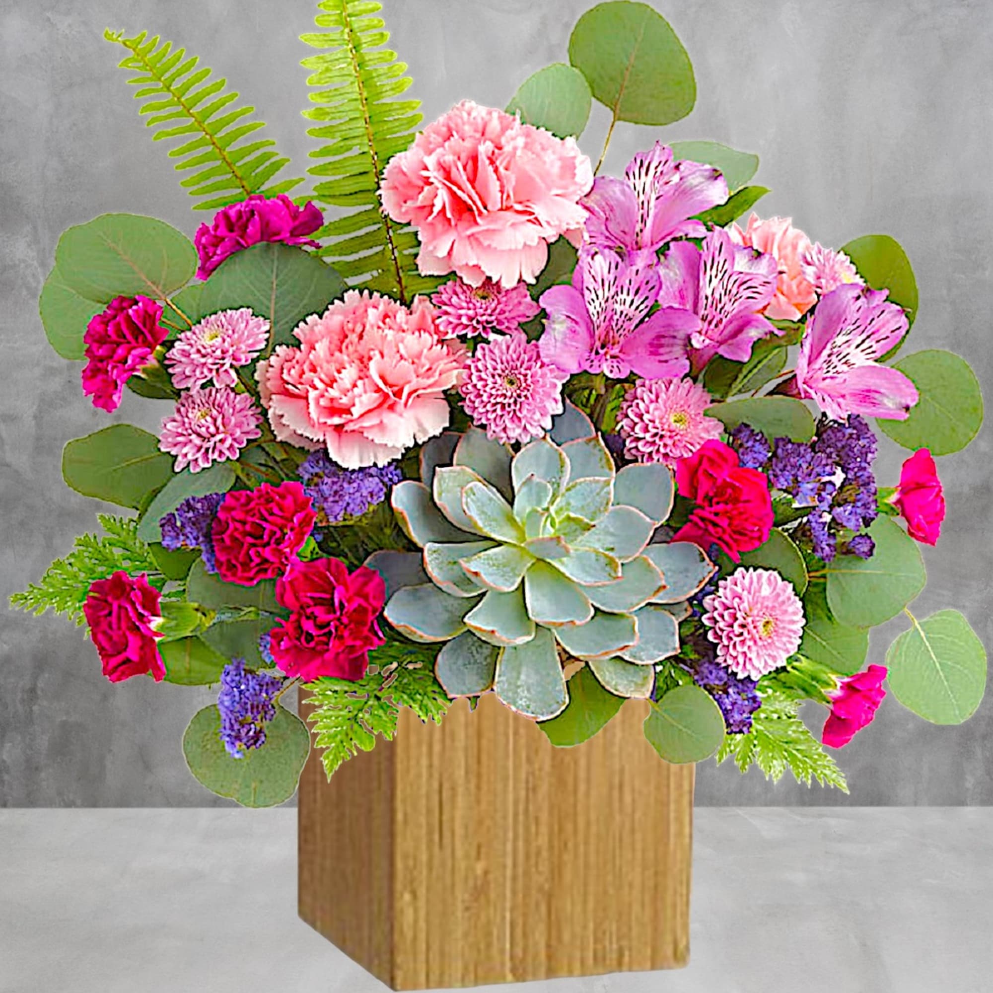 Mixed pink flowers and succulents in a wooden box