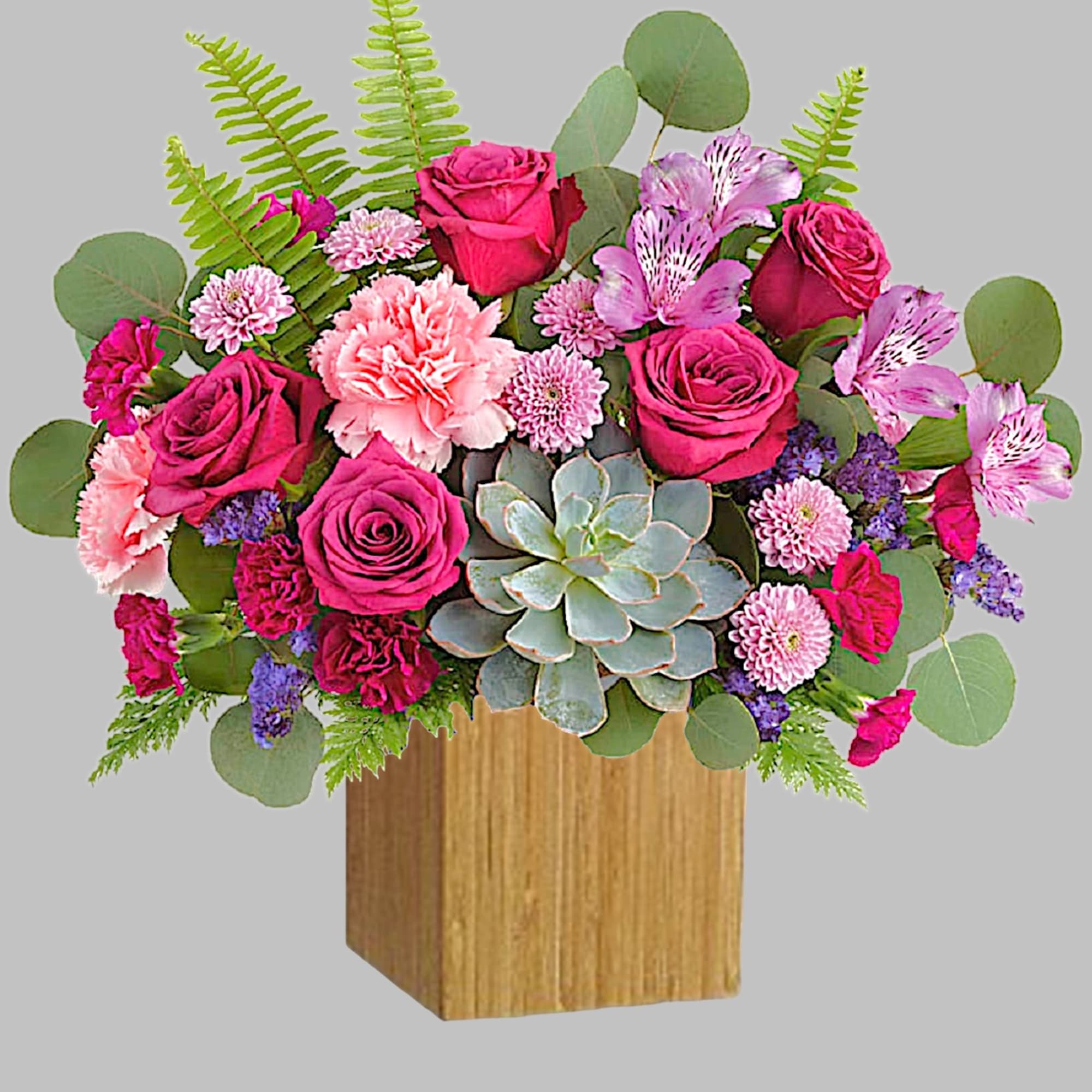 Pink roses and carnations with succulents in a wooden box