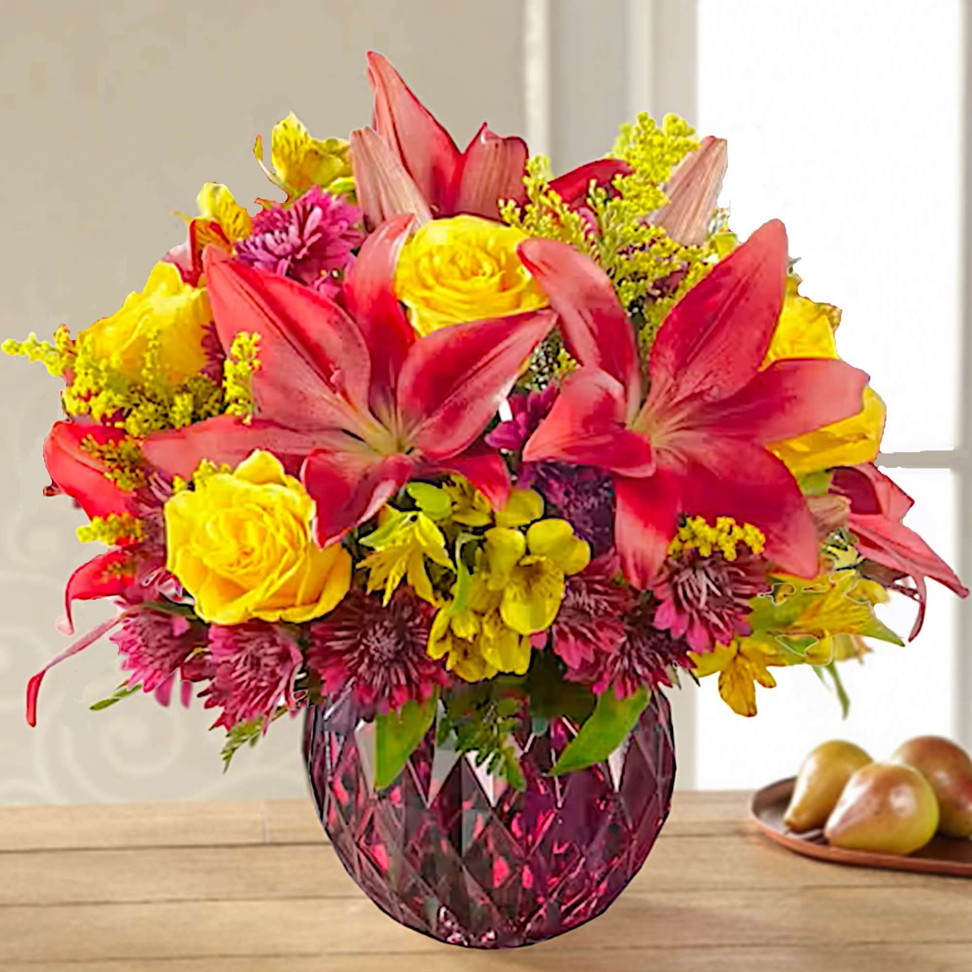Bright bouquet of pink lilies and yellow roses in a pink glass vase