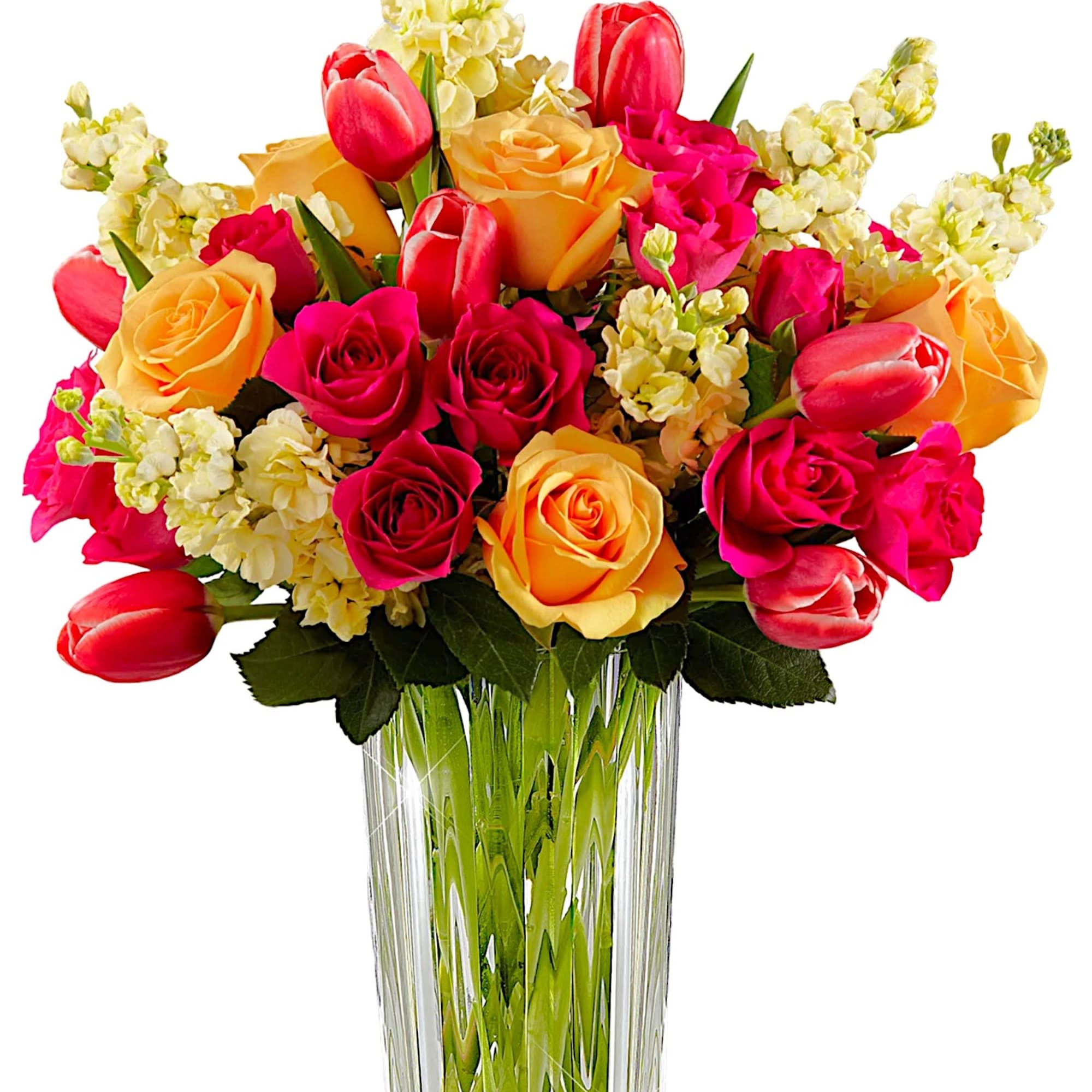 Bouquet of pink and yellow roses with tulips in a clear glass vase
