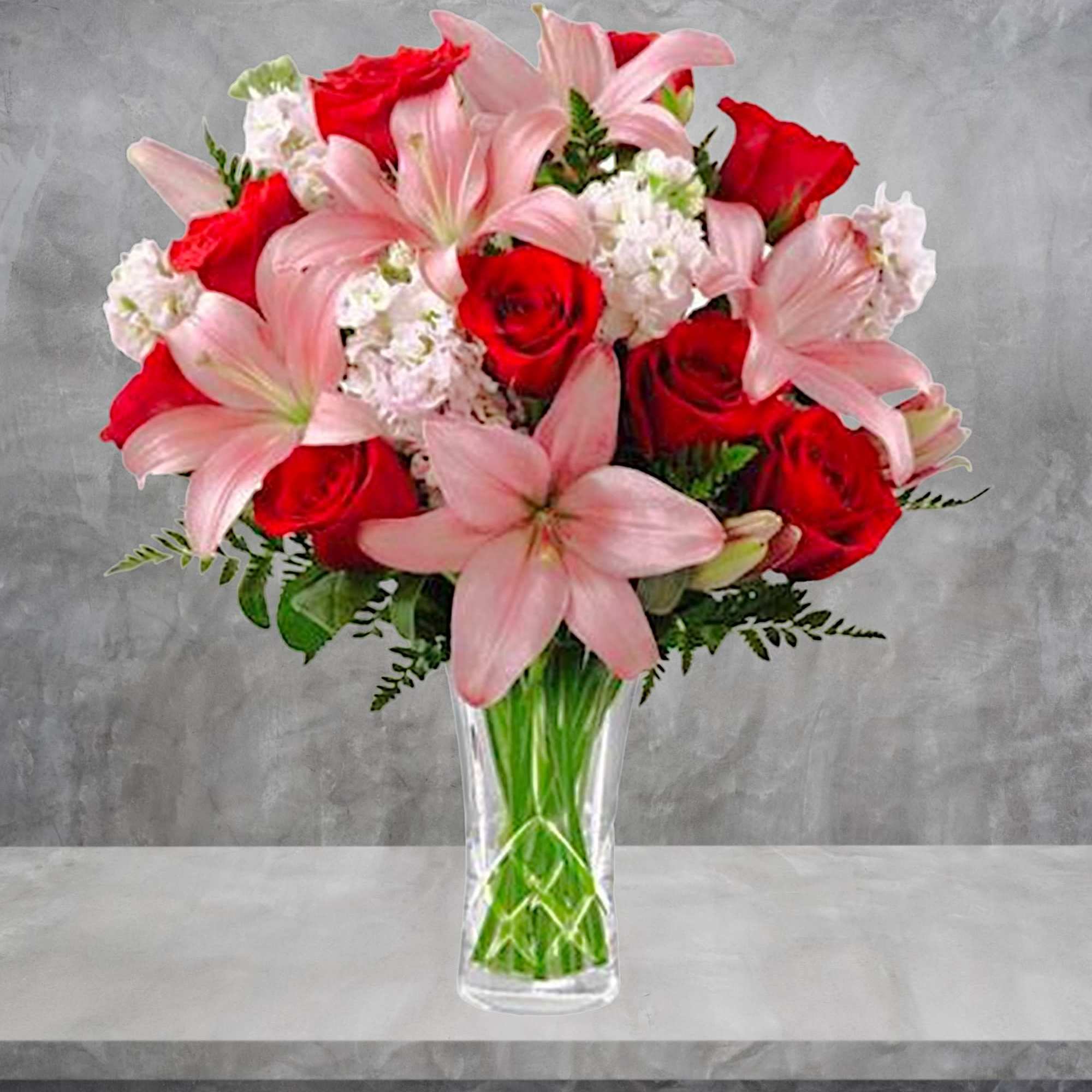 Bouquet of red roses and pink lilies in a clear glass vase, photo 2 of 4