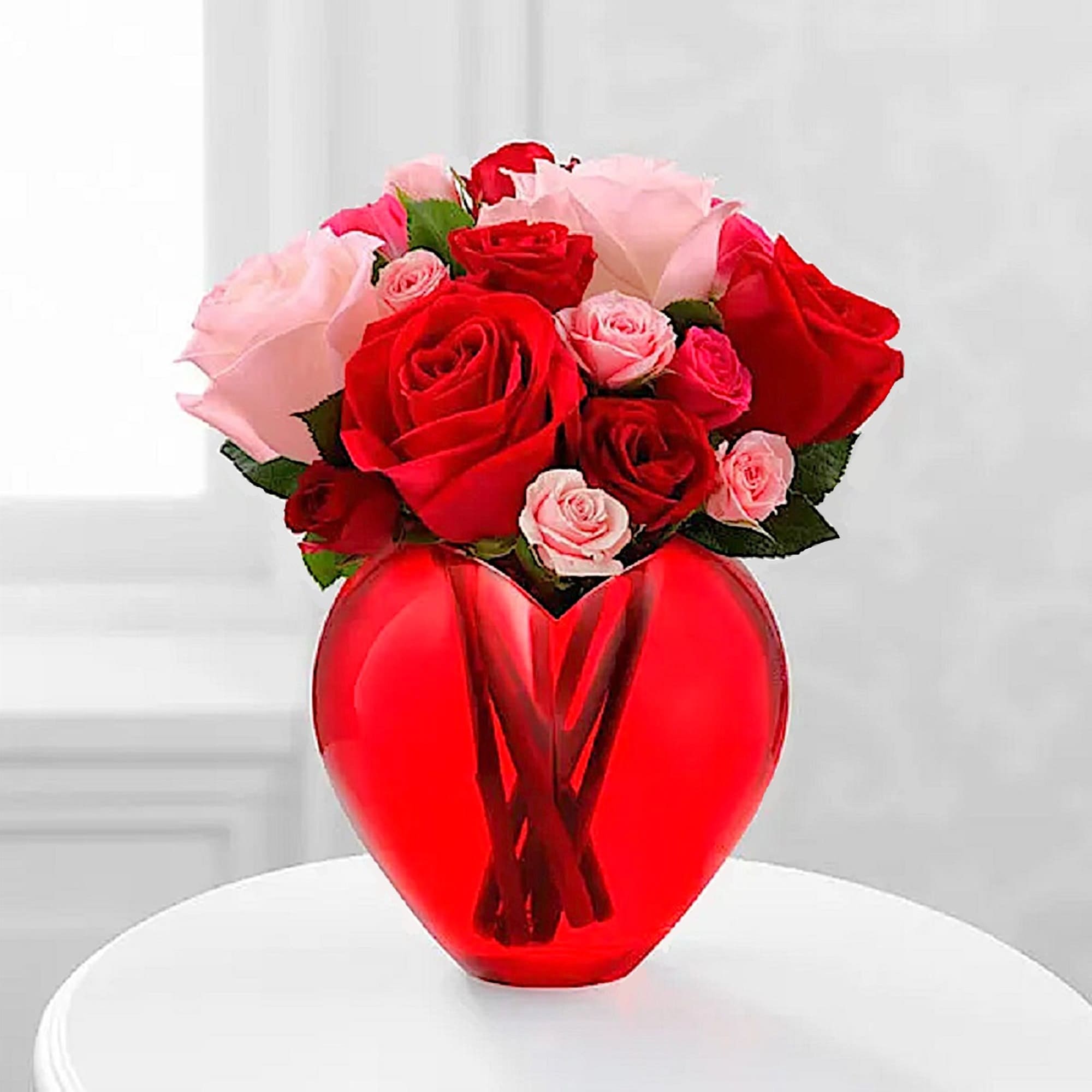 Red and pink roses arranged in a red heart-shaped vase, photo 2 of 5