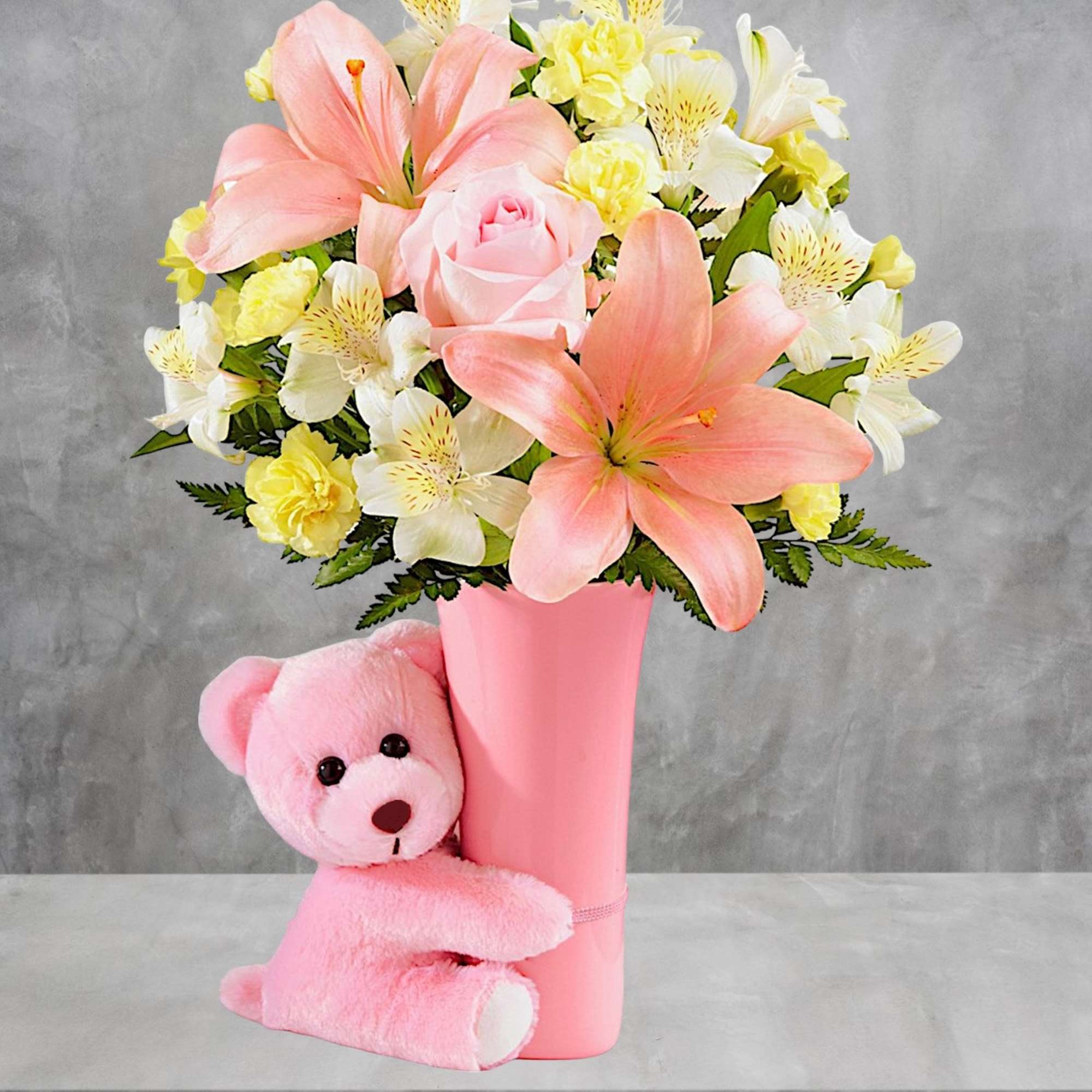 Pink and white flower arrangement in a pink vase with a pink teddy bear