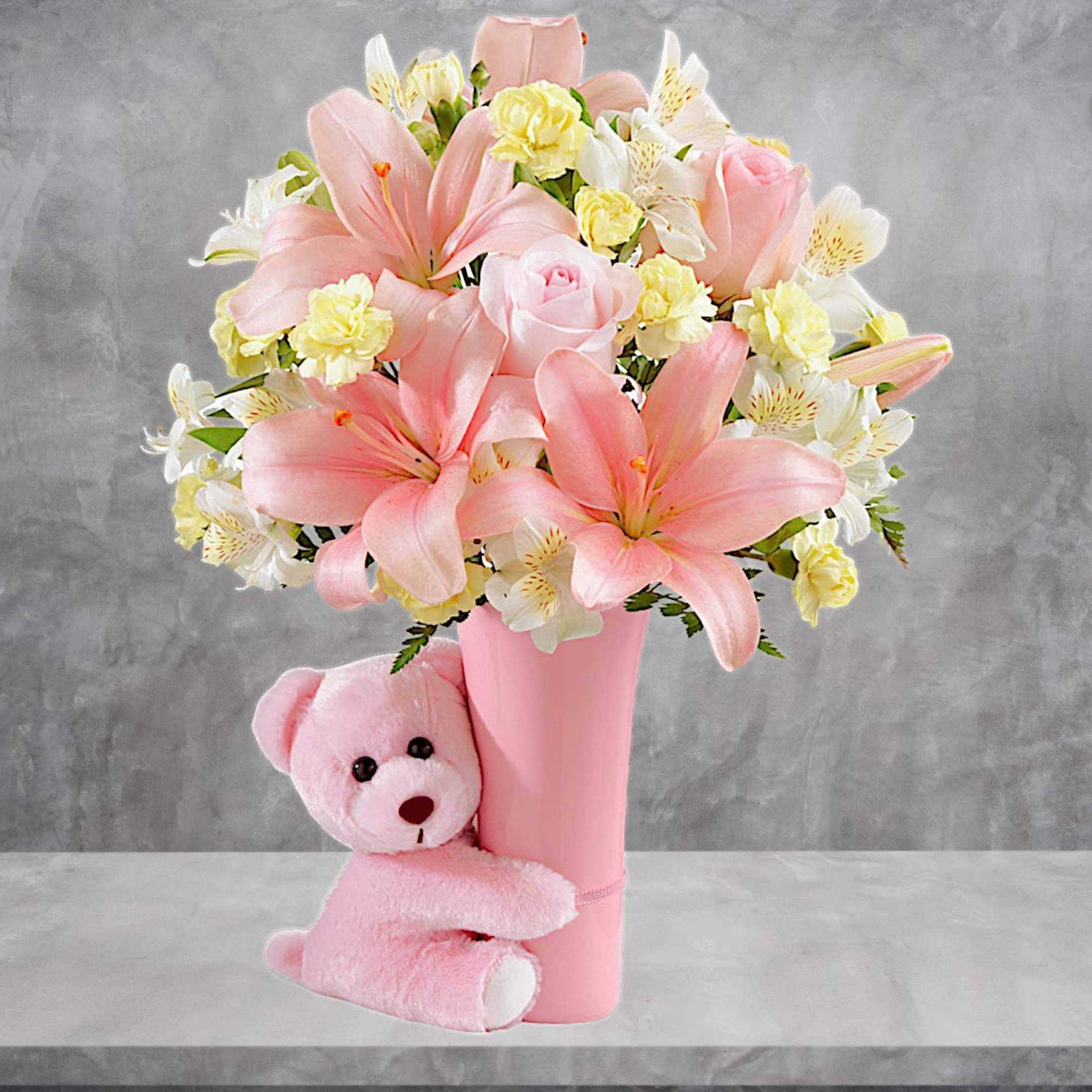 Pink and white flower arrangement in a pink vase with a teddy bear