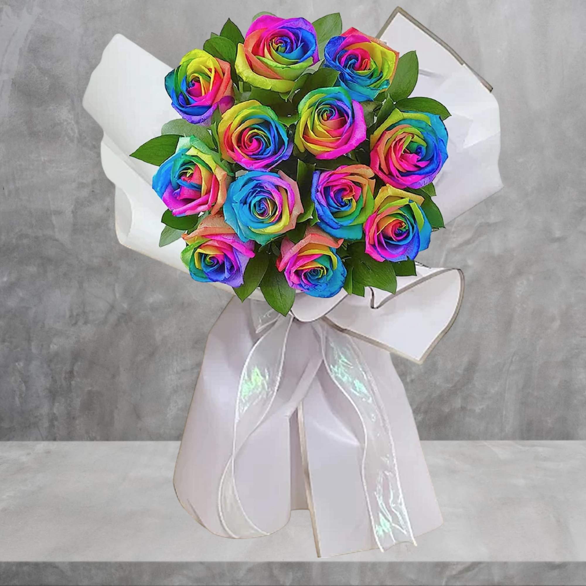 Bouquet of rainbow-colored roses wrapped in white paper with a ribbon, photo 2 of 4