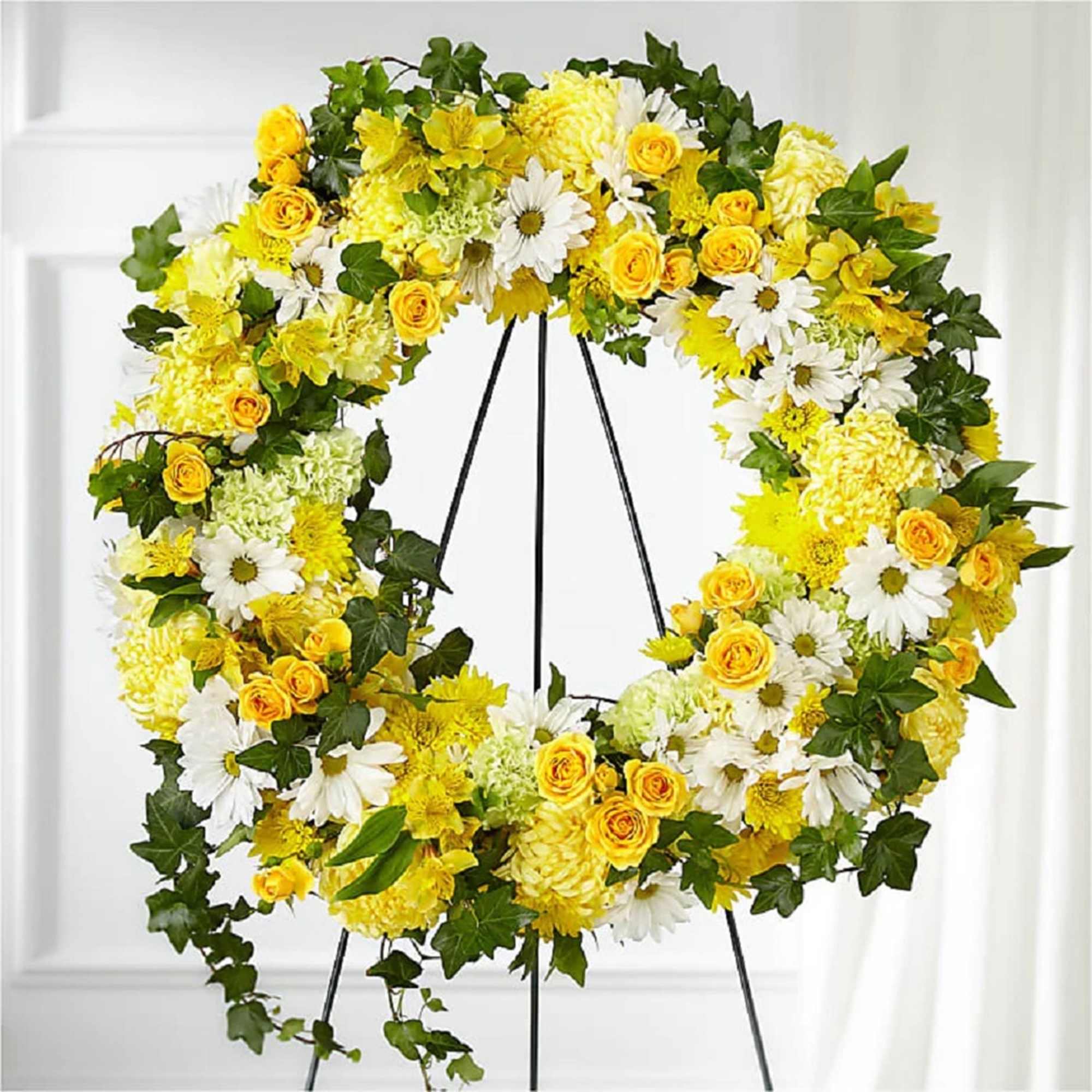 Yellow and white floral wreath on a black stand