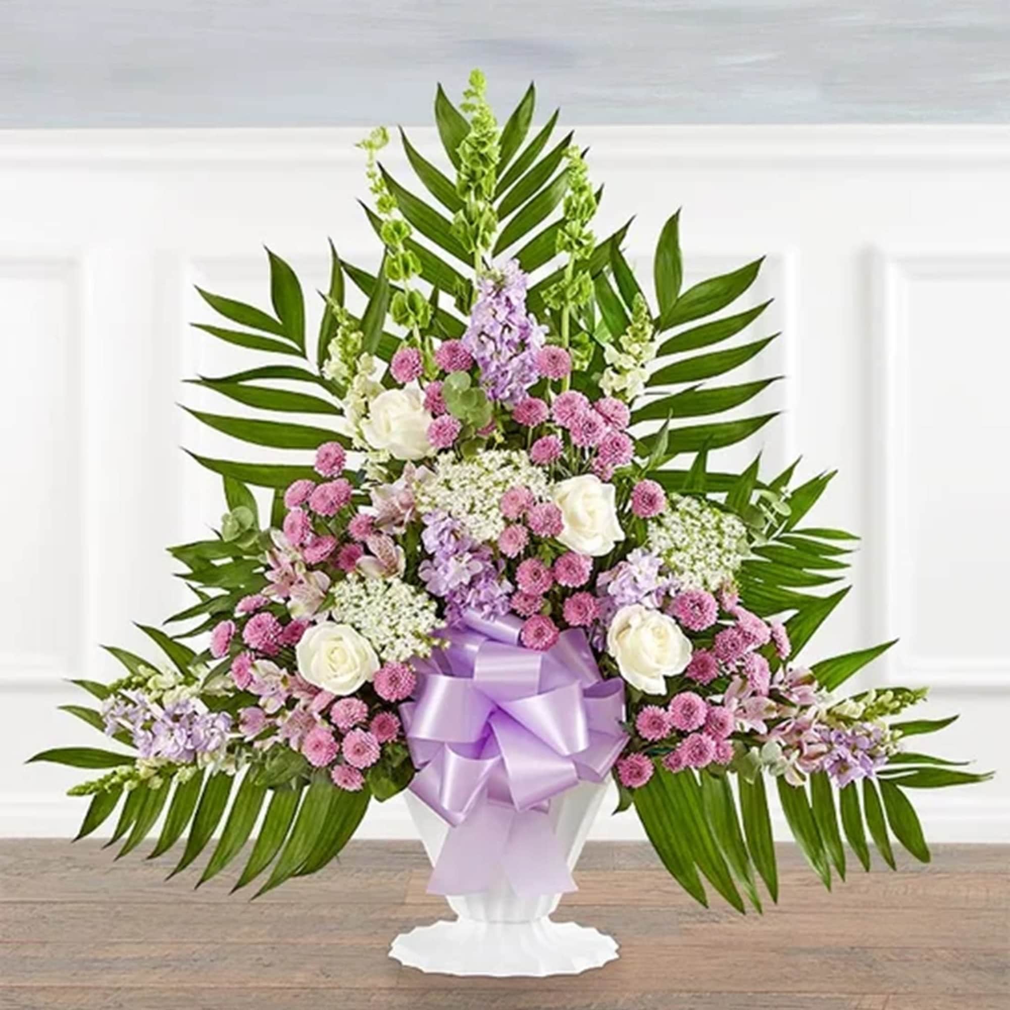 Large floral arrangement with pink and white blooms in a white vase