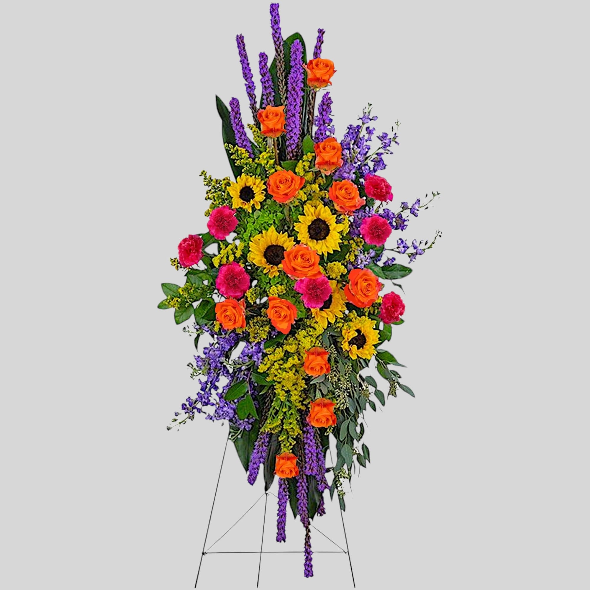 Tall standing floral spray with orange roses, sunflowers, purple flowers, and pink carnations