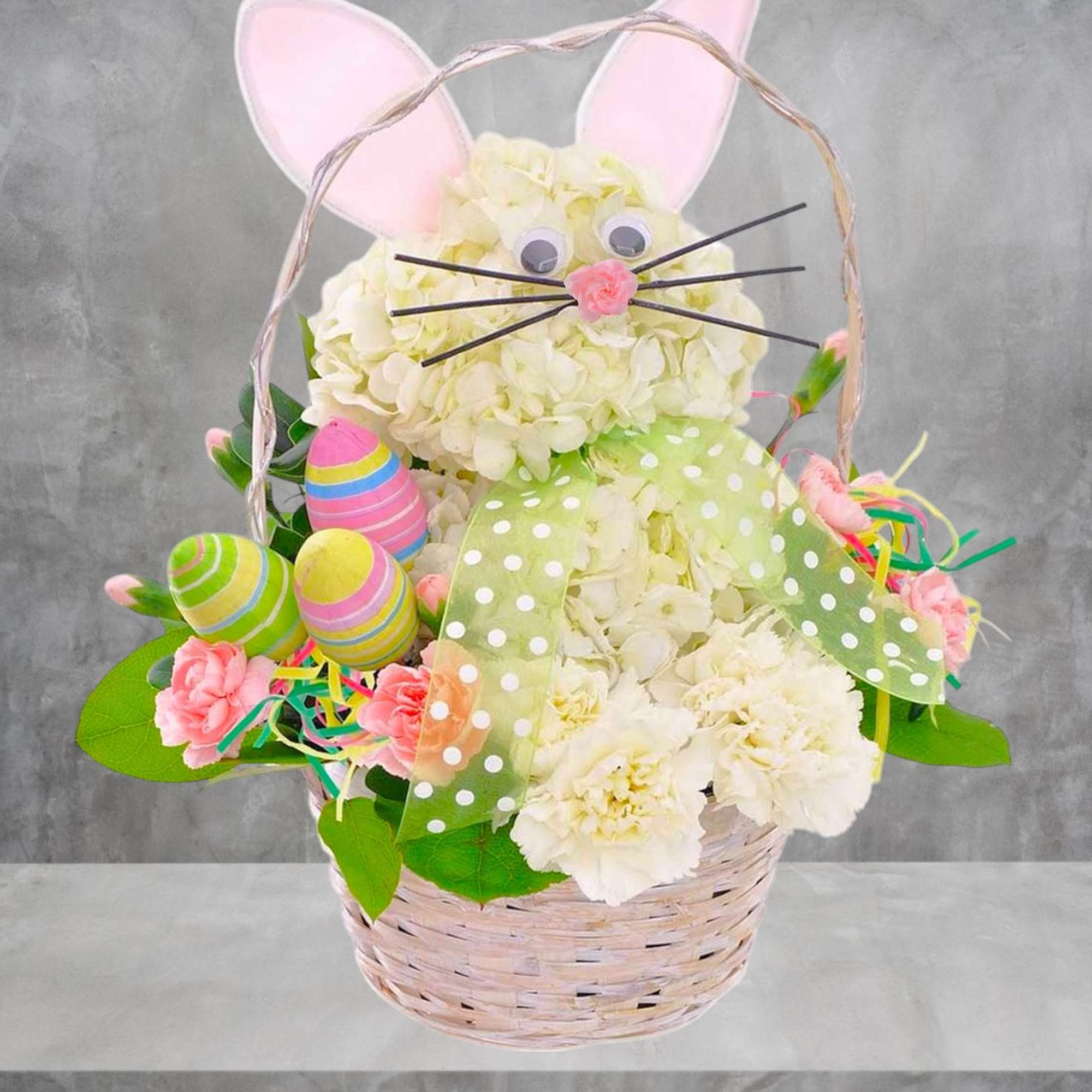 Easter basket arrangement shaped like a bunny with white flowers and pastel decorations