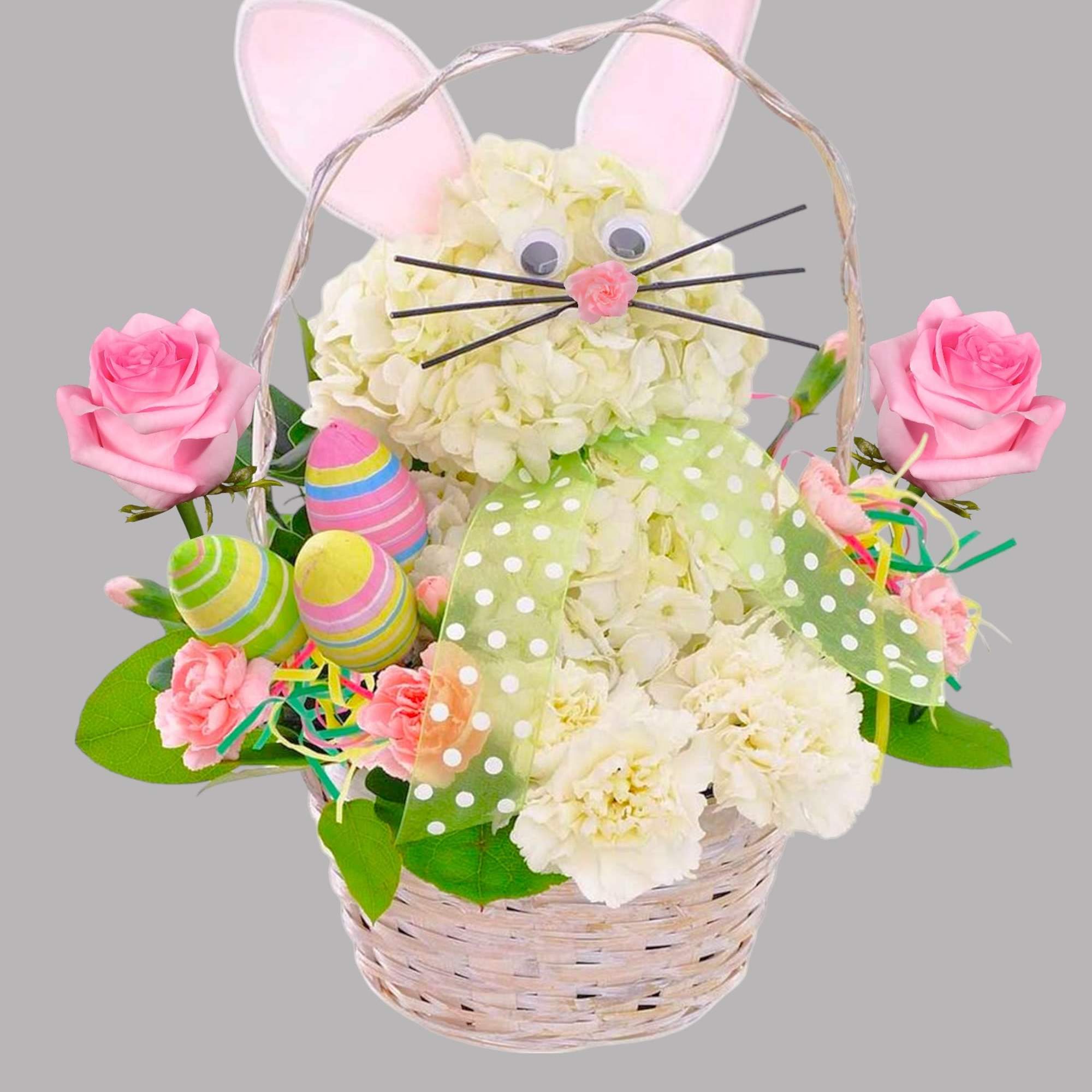 Easter basket arrangement with white flowers, pink roses, and bunny ears