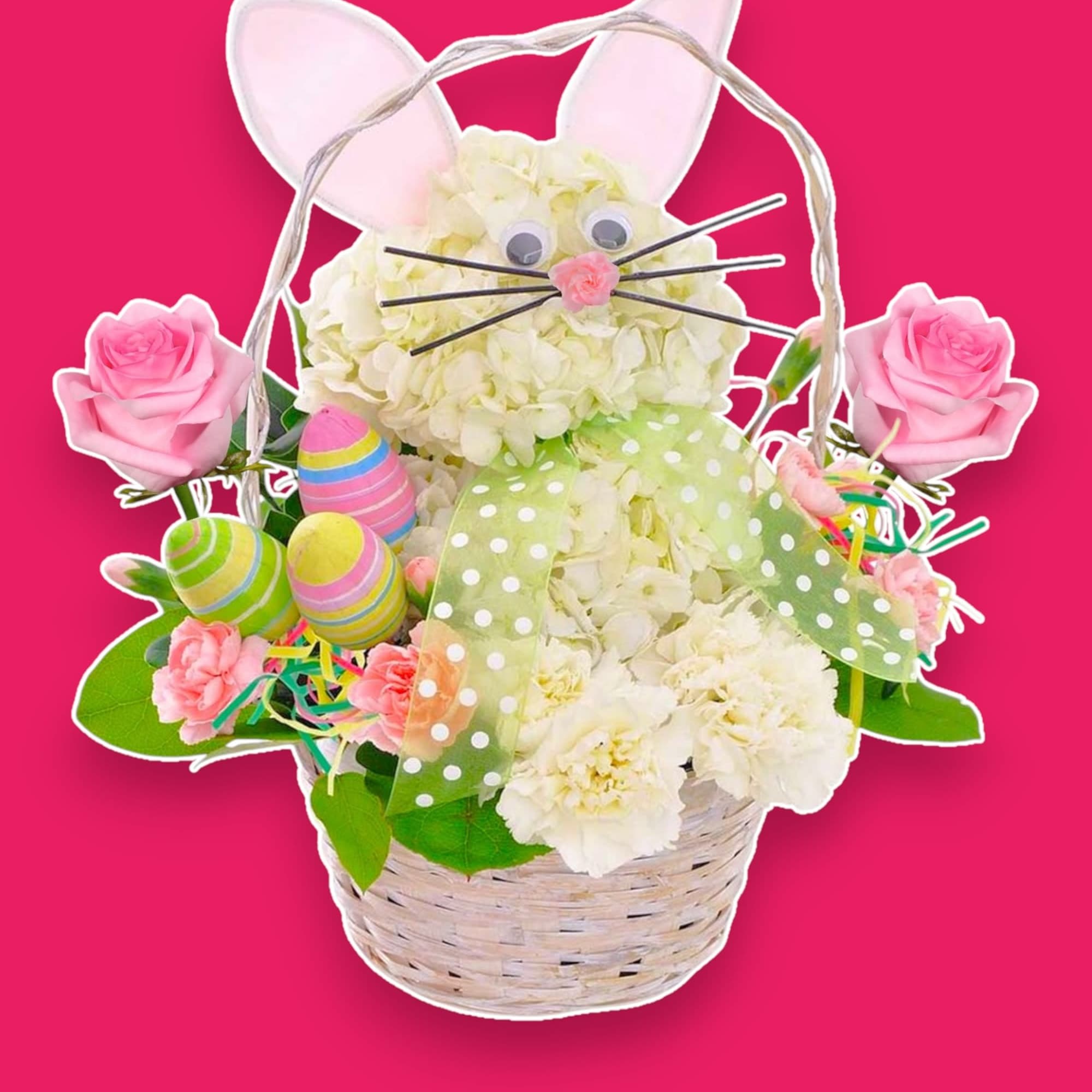 Basket arrangement with a bunny face, pink roses, and pastel Easter eggs