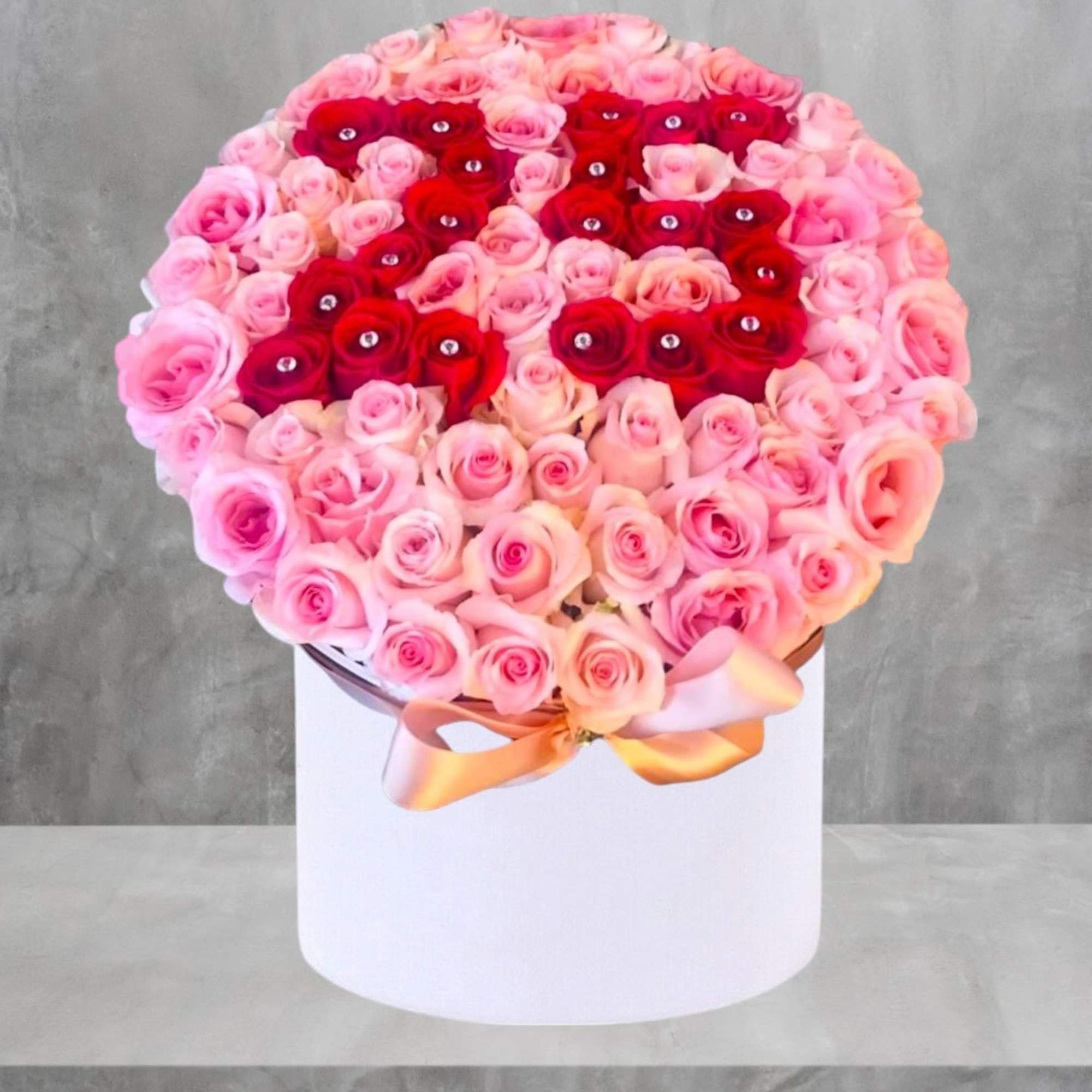Round box of pink and red roses with a ribbon bow, photo 3 of 8