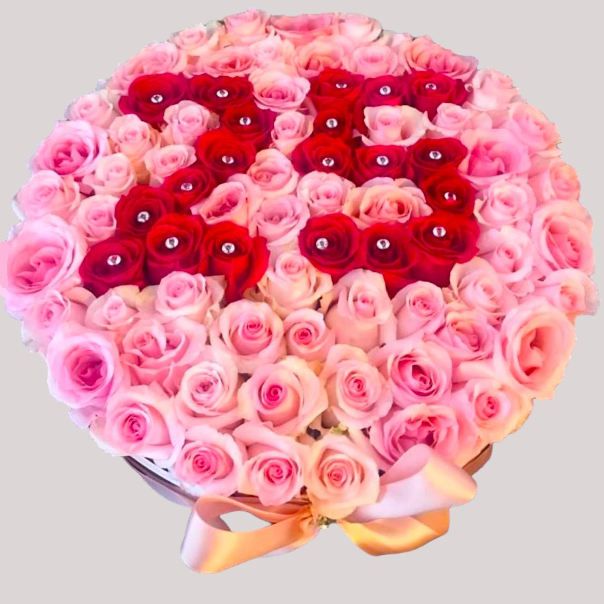 Round bouquet of pink and red roses with a satin ribbon