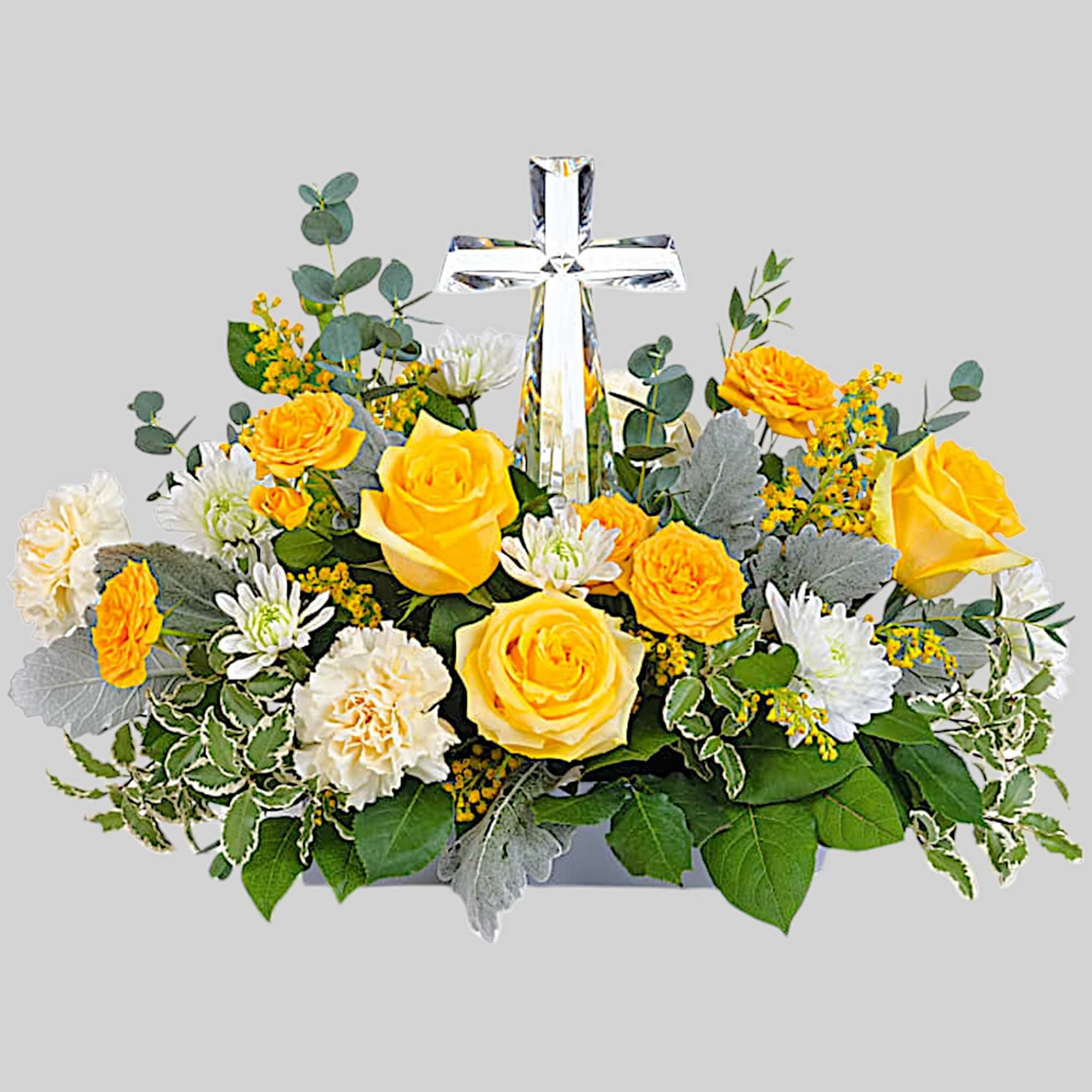 Yellow and white flowers arranged around a clear glass cross