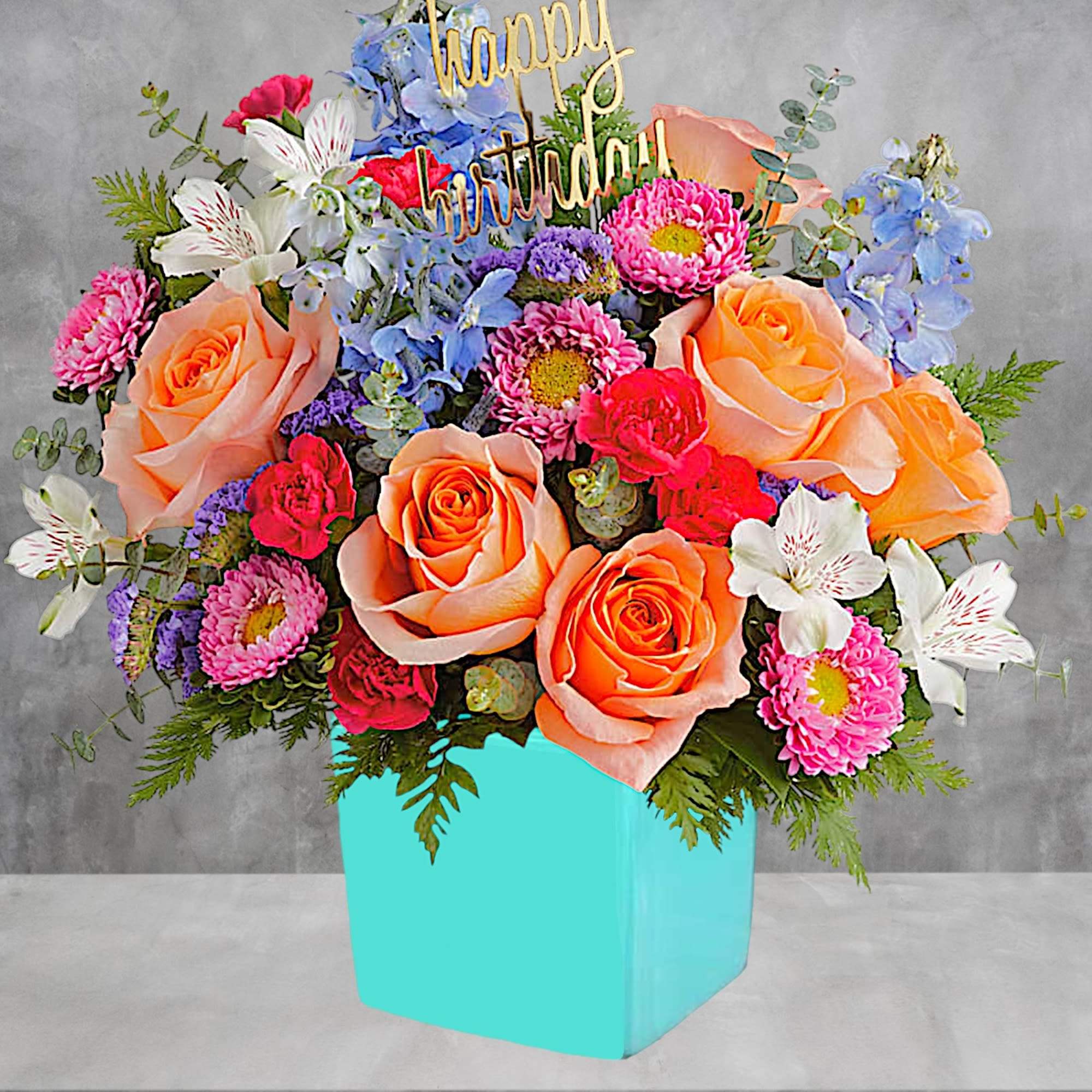 Colorful birthday bouquet in a turquoise box with a gold topper