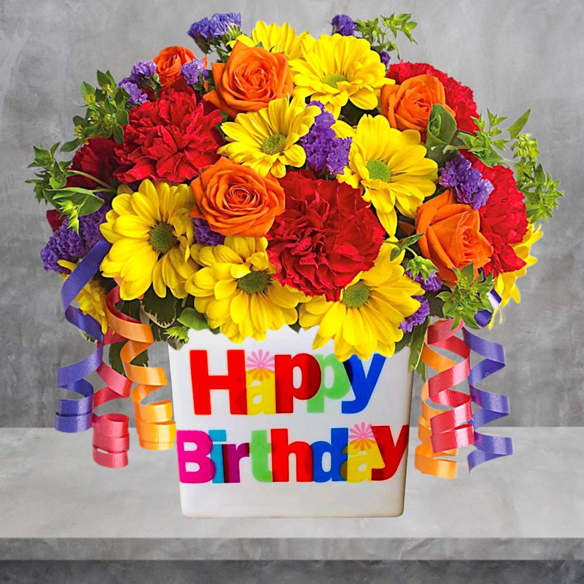 Bright mixed bouquet in a white Happy Birthday container with curled ribbons