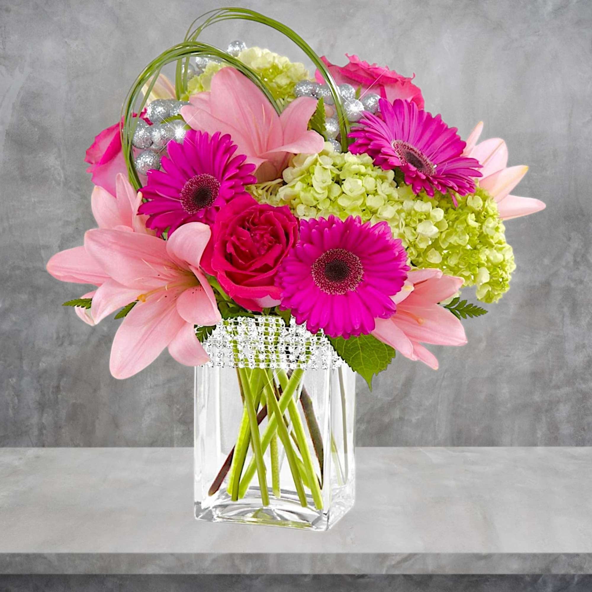 Pink and magenta flowers arranged in a clear glass vase