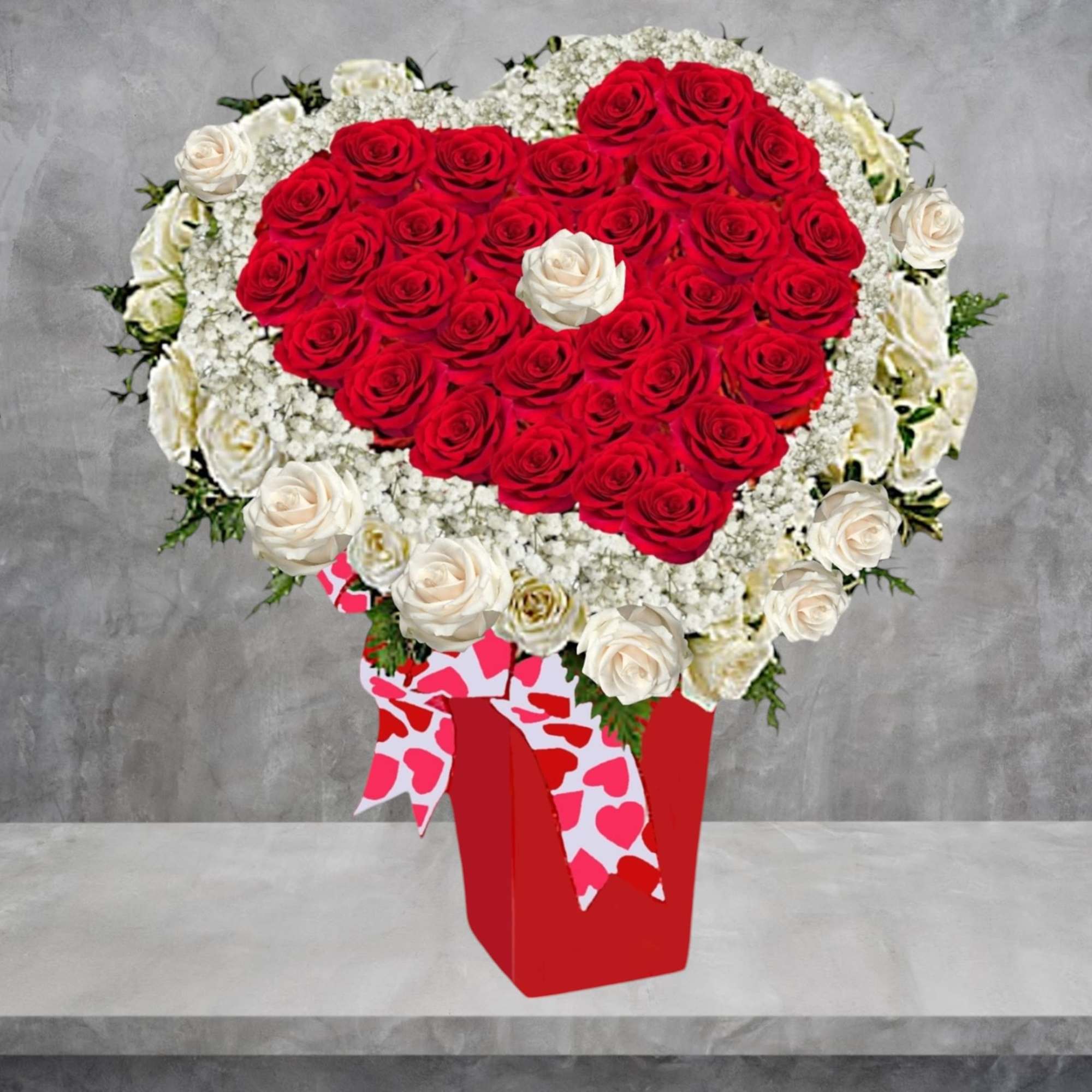 Heart-shaped bouquet of red and white roses in a red box