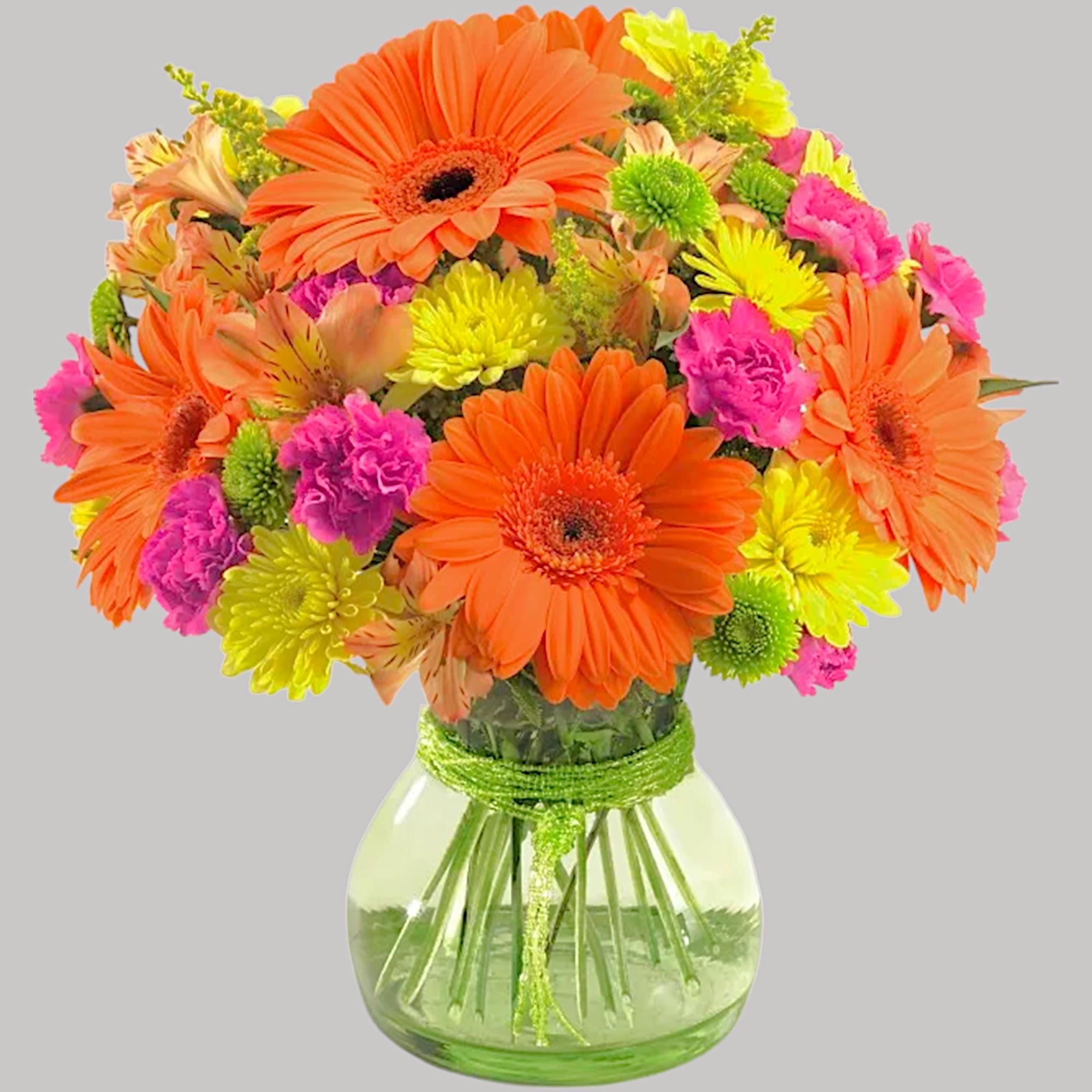 Bright mixed bouquet of gerbera daisies and carnations in a glass vase