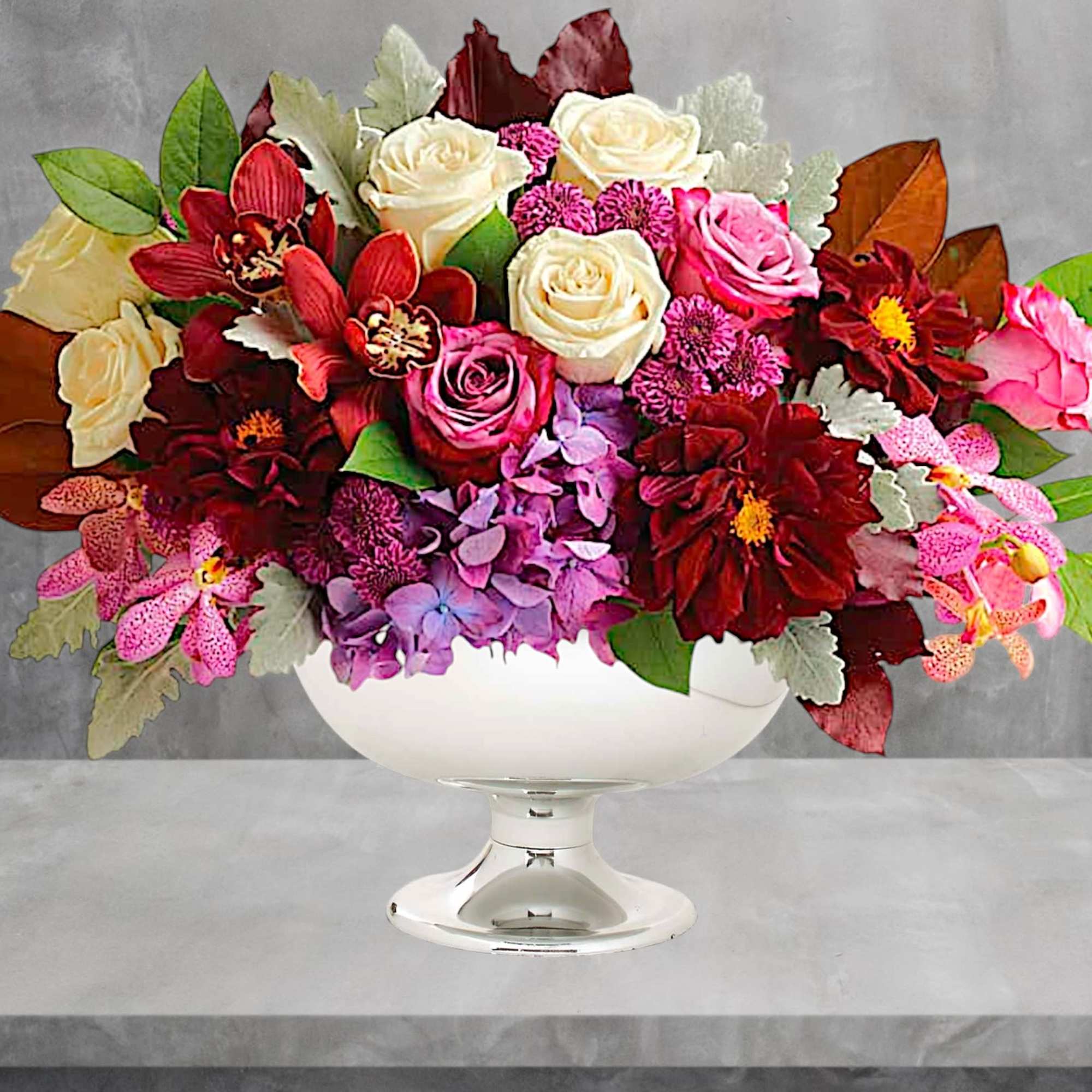 Mixed bouquet of roses and orchids in a white pedestal vase