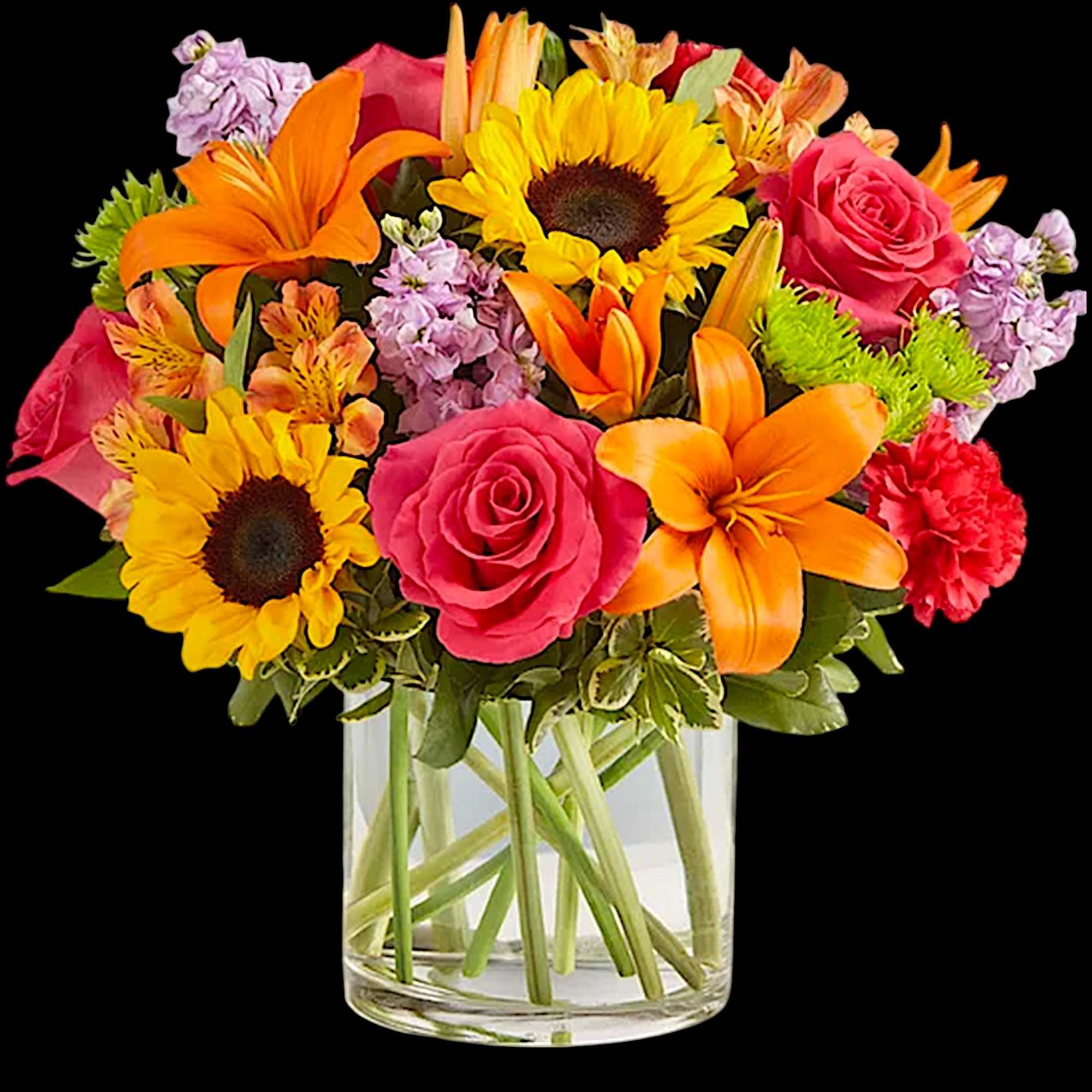 Mixed bouquet of sunflowers, roses, lilies, and carnations in a clear glass vase