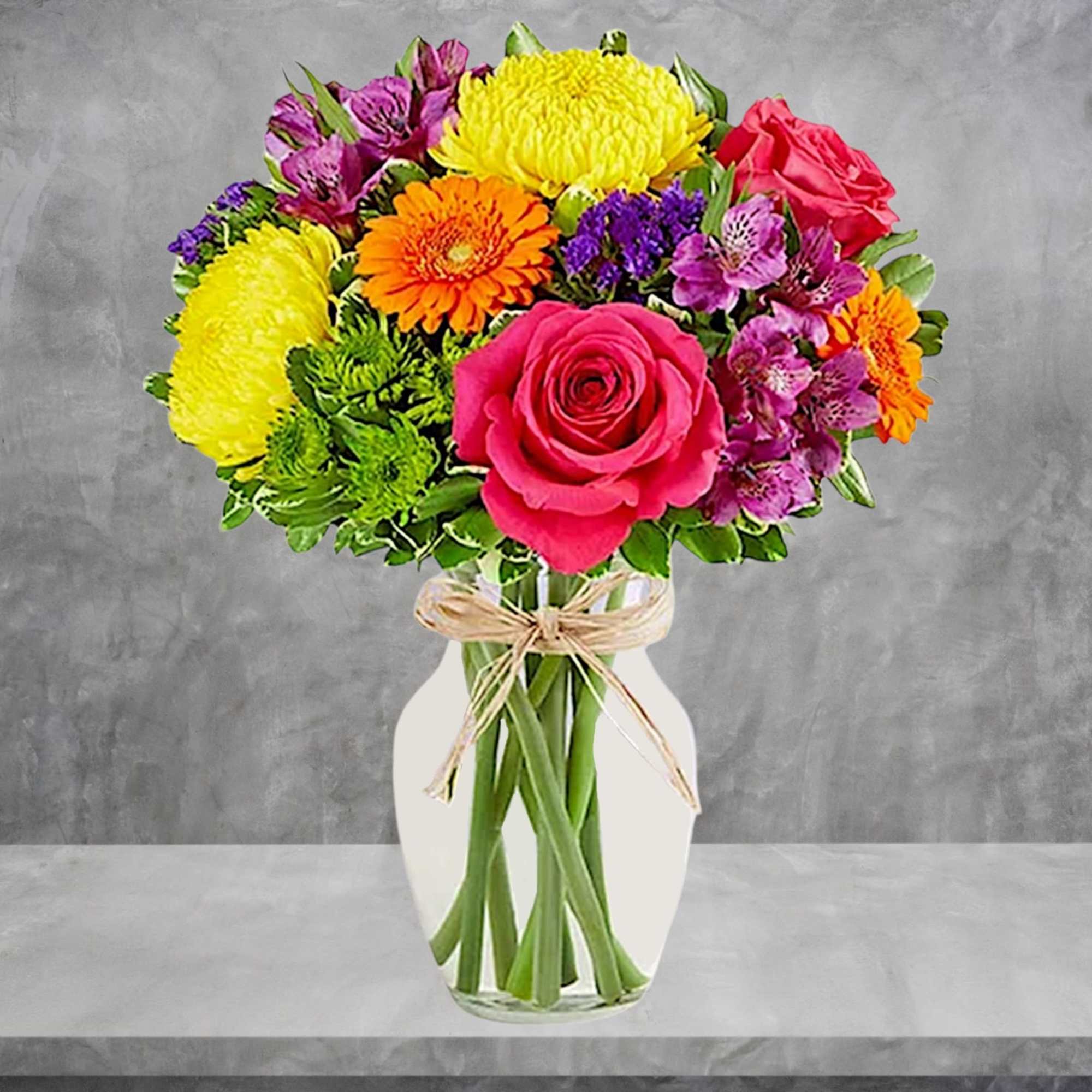 Colorful bouquet of roses, daisies, and alstroemeria in a white vase