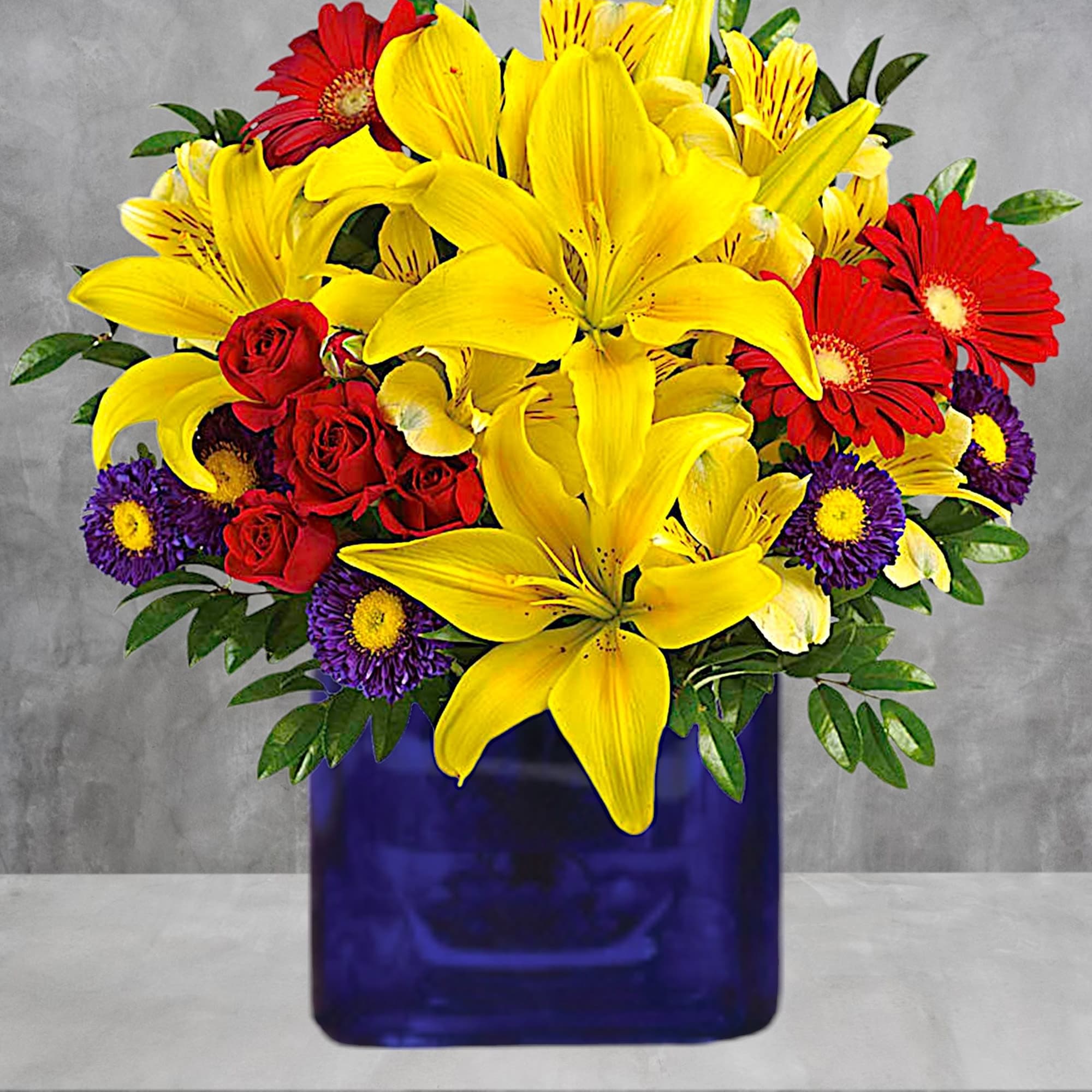 Bouquet of yellow lilies, red roses, and purple daisies in a blue vase, photo 2 of 4