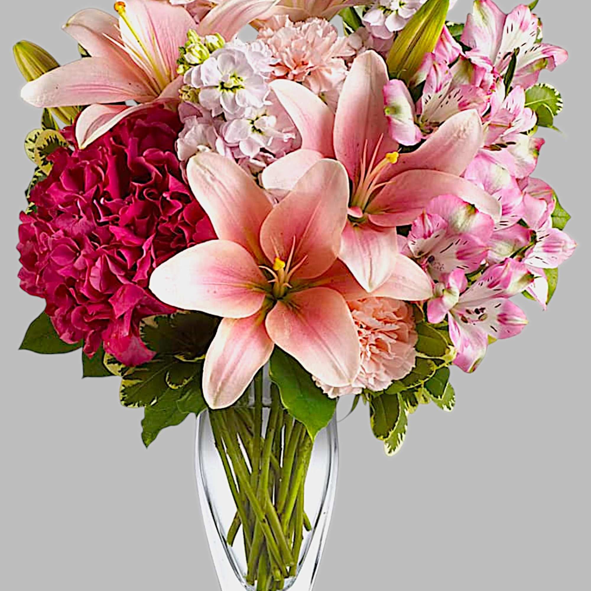 Pink lilies and hydrangeas arranged in a clear glass vase, photo 4 of 4