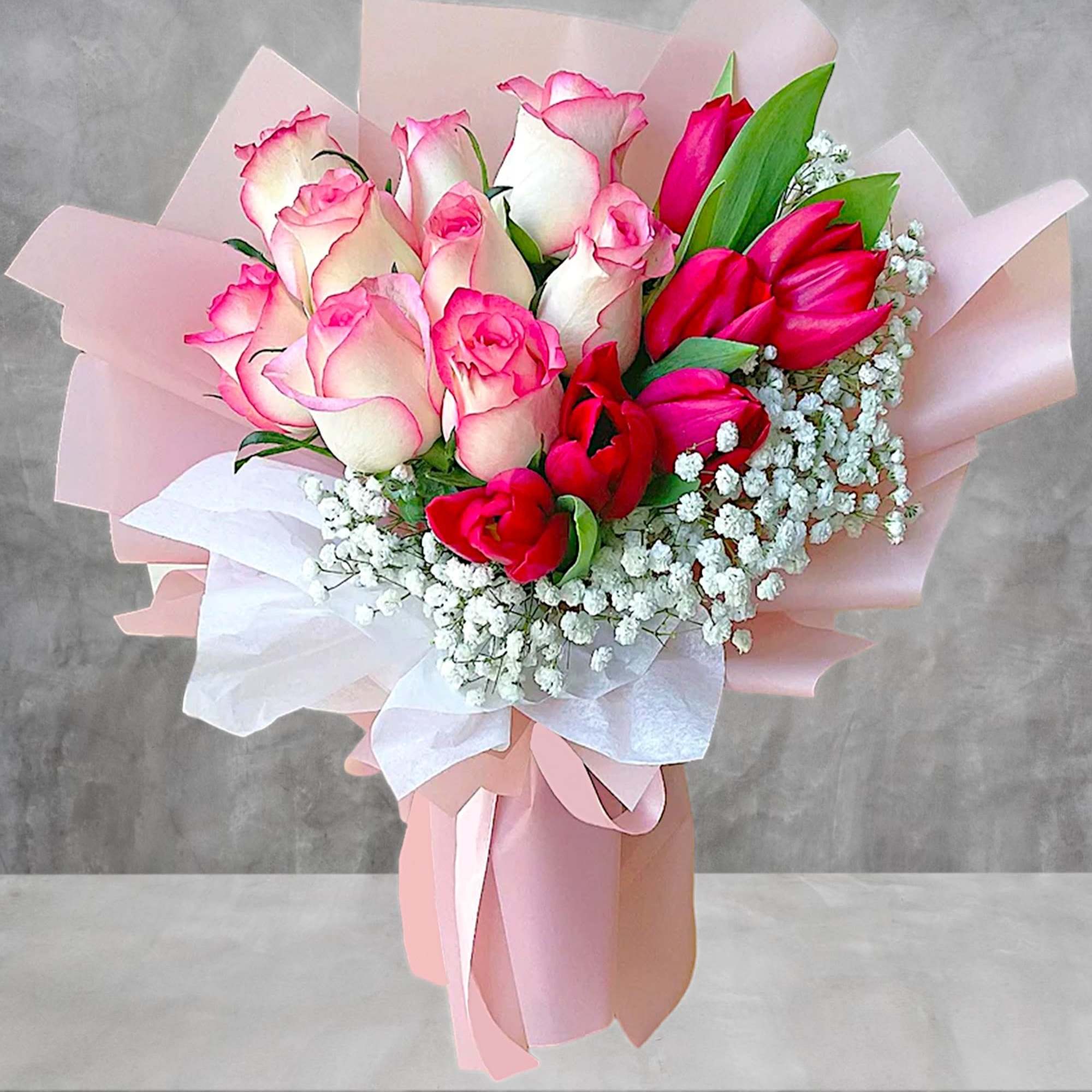 Bouquet of pink and white roses with red tulips and baby's breath