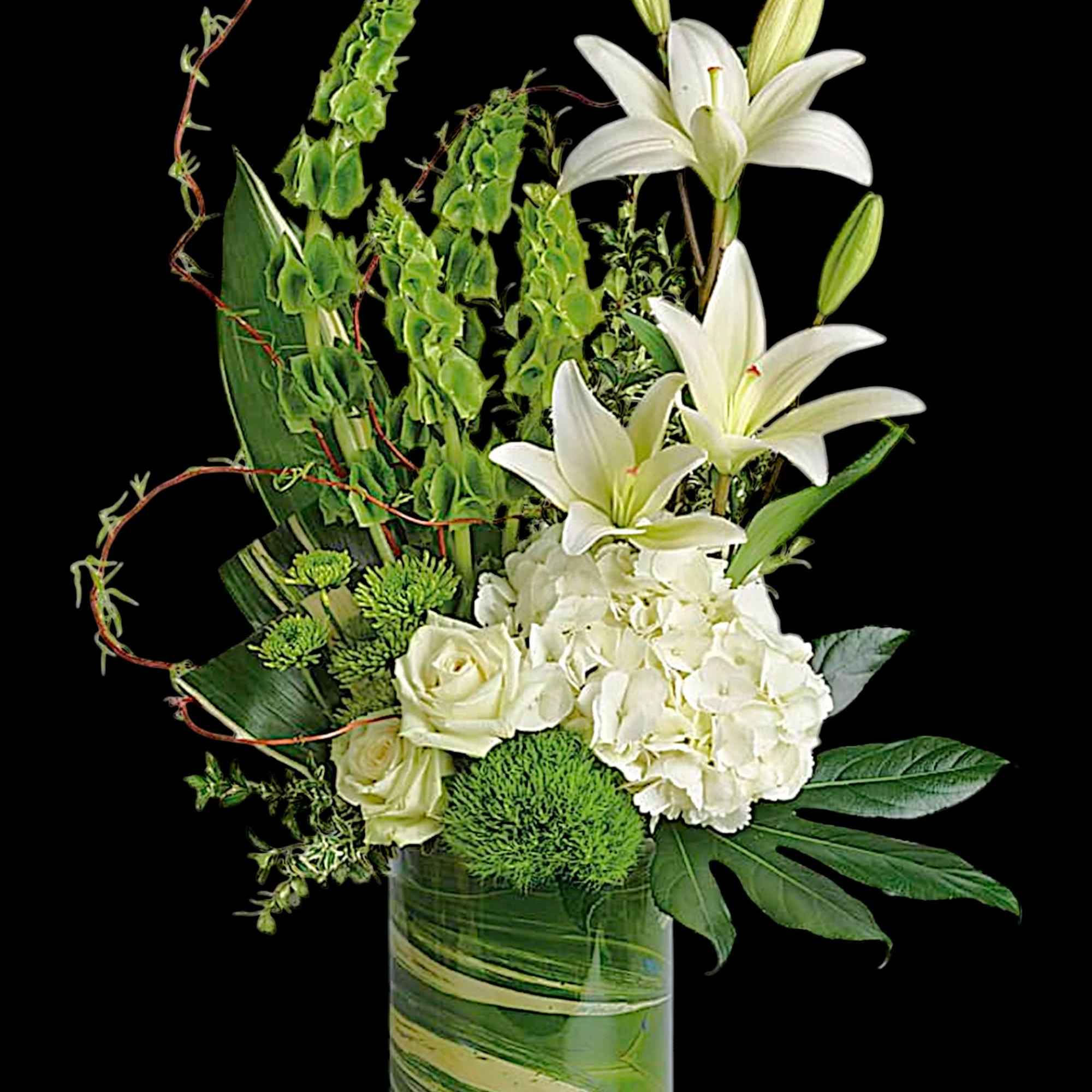 White lilies and roses in a glass vase with green accents
