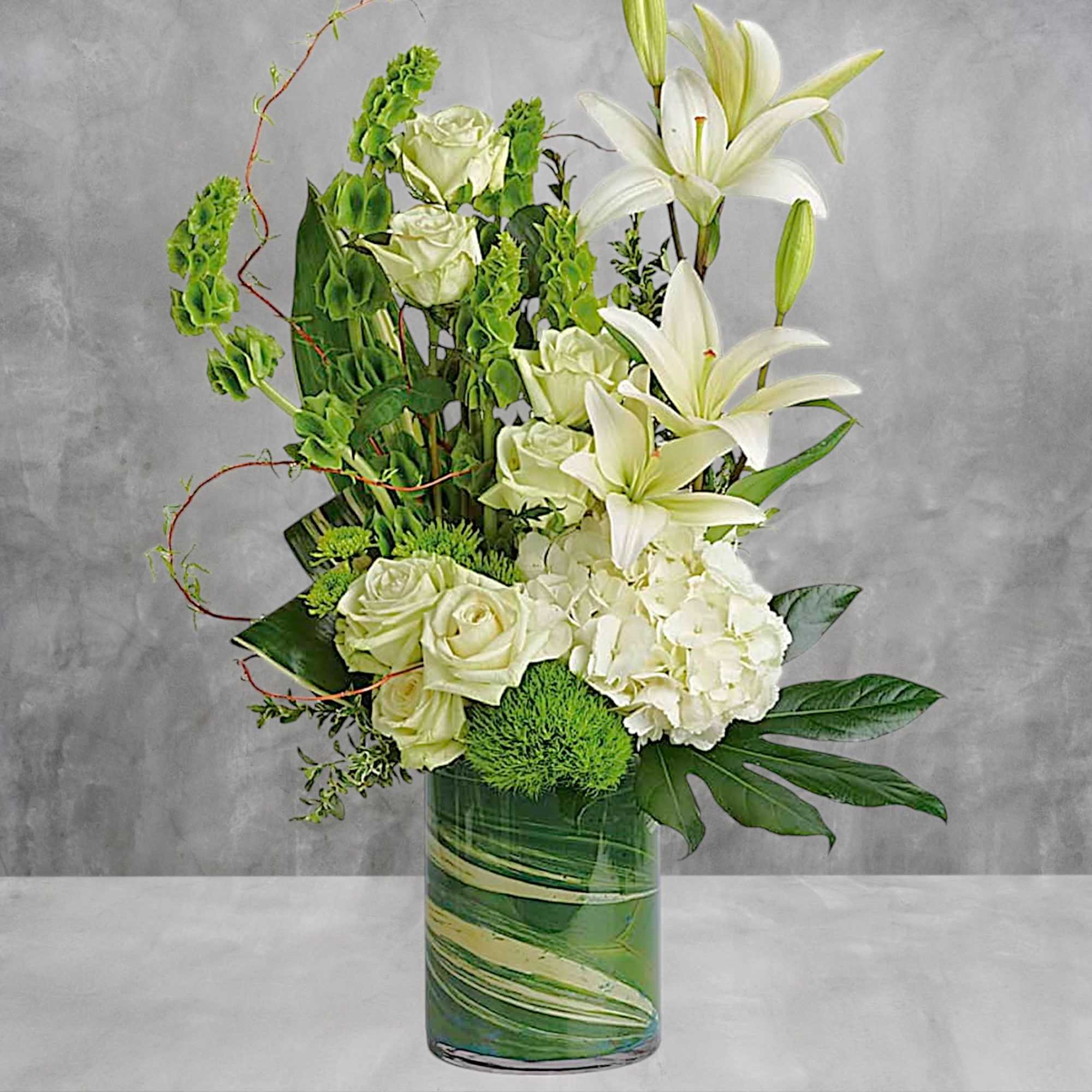White lilies and roses arranged in a glass vase