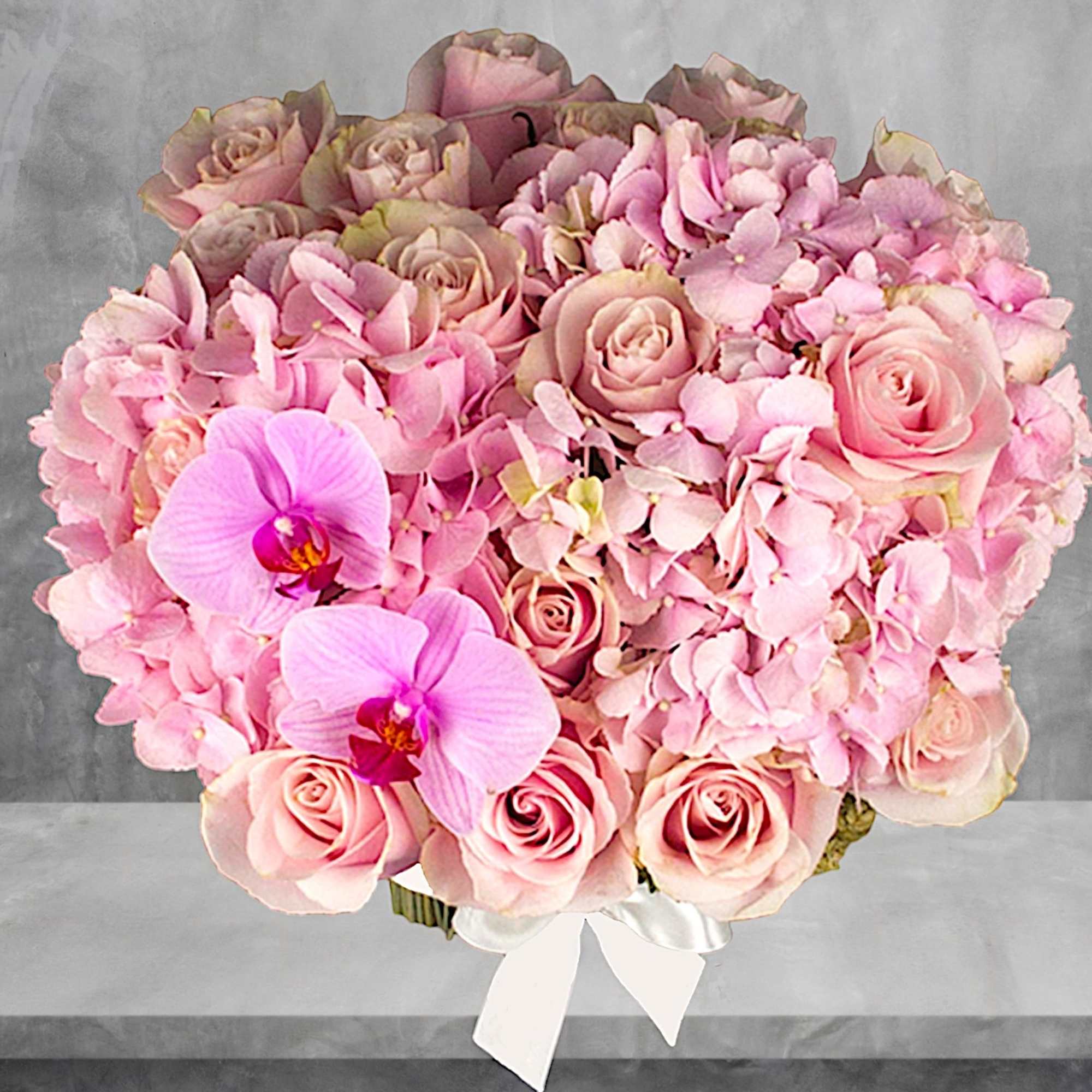 Pink rose and orchid bouquet with hydrangea, tied with a white ribbon