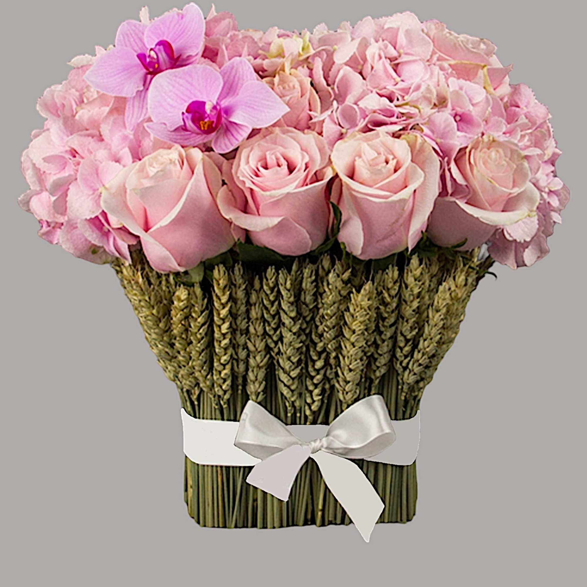 Pink roses and orchids arranged in a woven basket with a white ribbon, photo 11 of 11