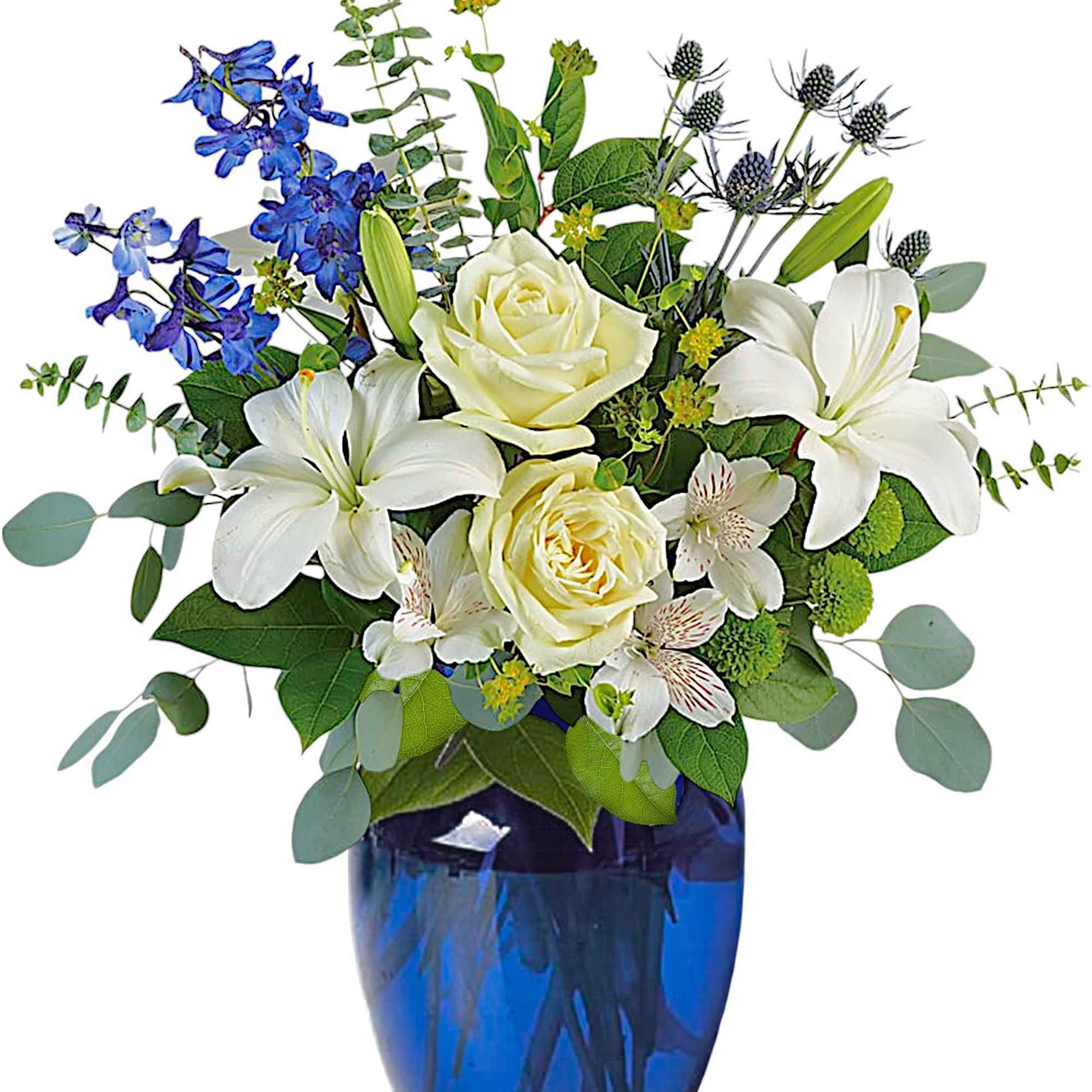White roses and lilies in a blue glass vase with blue flowers